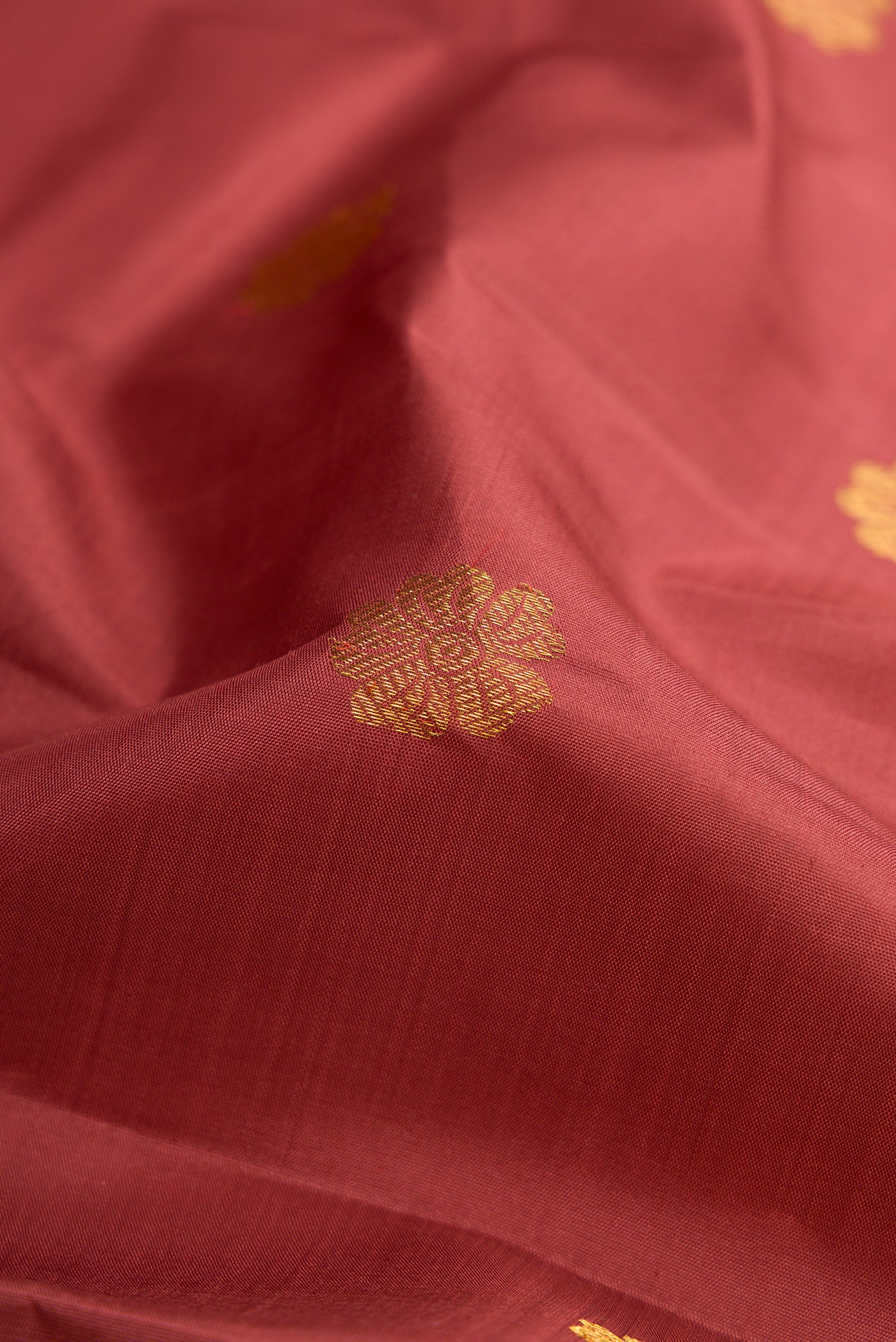 Close up of Maroon Dual Tone Kanjivaram Silk Saree with Zari Butta on the body and Zari Border.  displaying folds