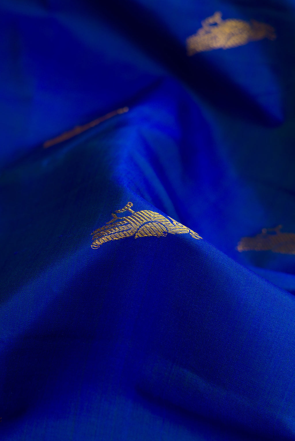 Close up of Royal Blue Dual Tone Kanchipuram Silk Saree with Zari Butta on the body and Zari Border.  displaying folds