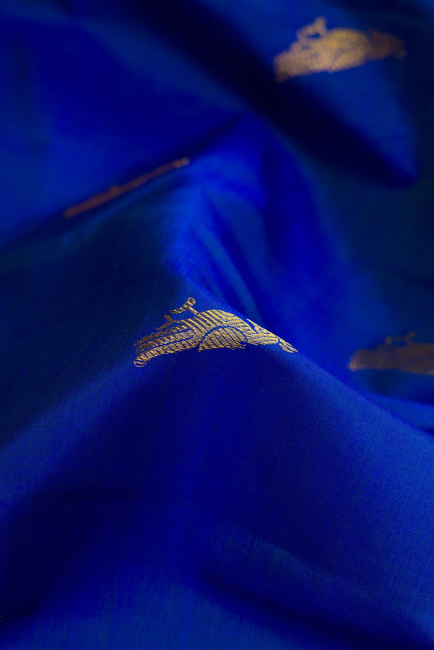 Close up of Royal Blue Dual Tone Kanchipuram Silk Saree with Zari Butta on the body and Zari Border.  displaying folds