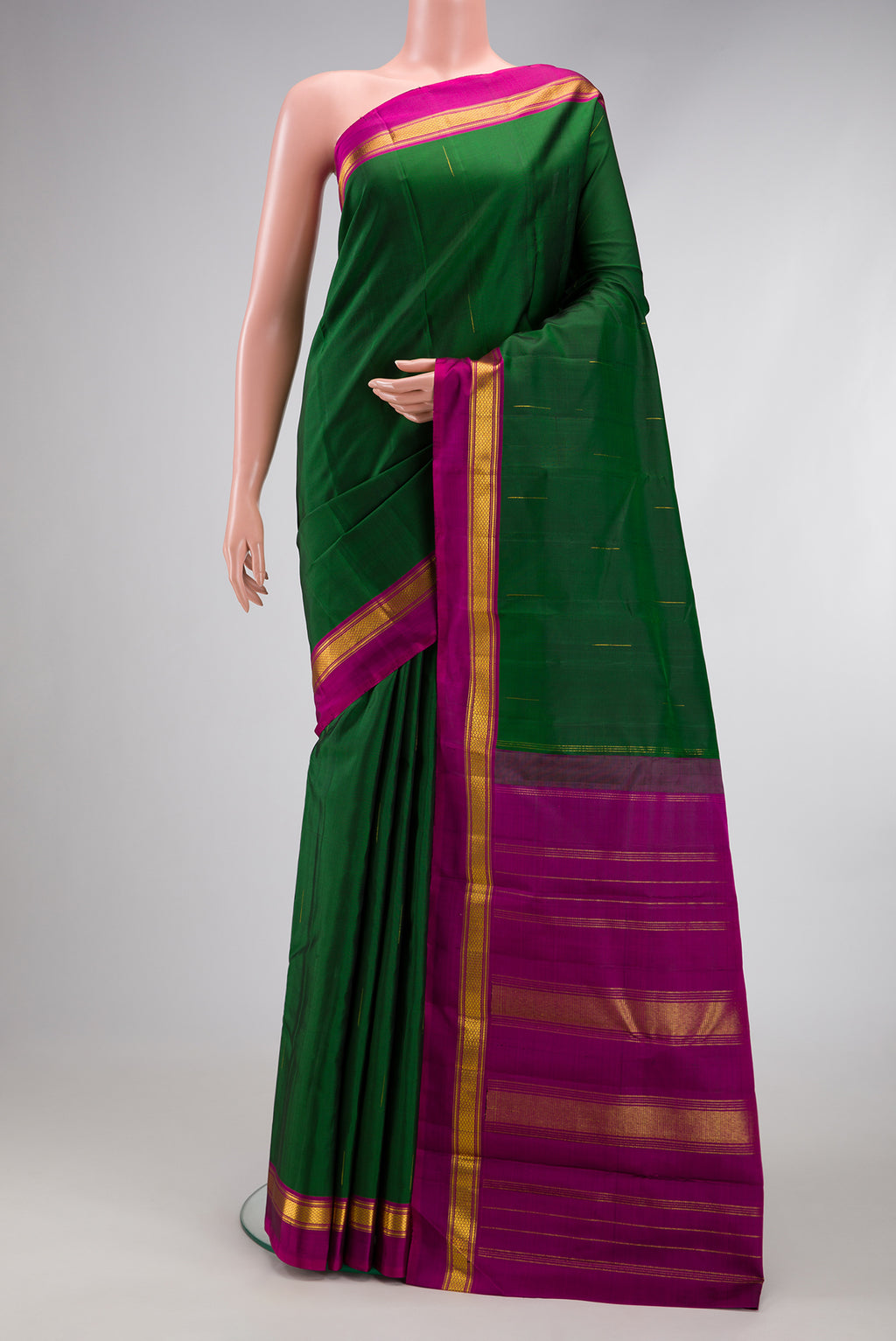 Bottle Green Kanchipuram Silk Saree with Zari Butta on the body and Zari Border.  displayed on a mannequin