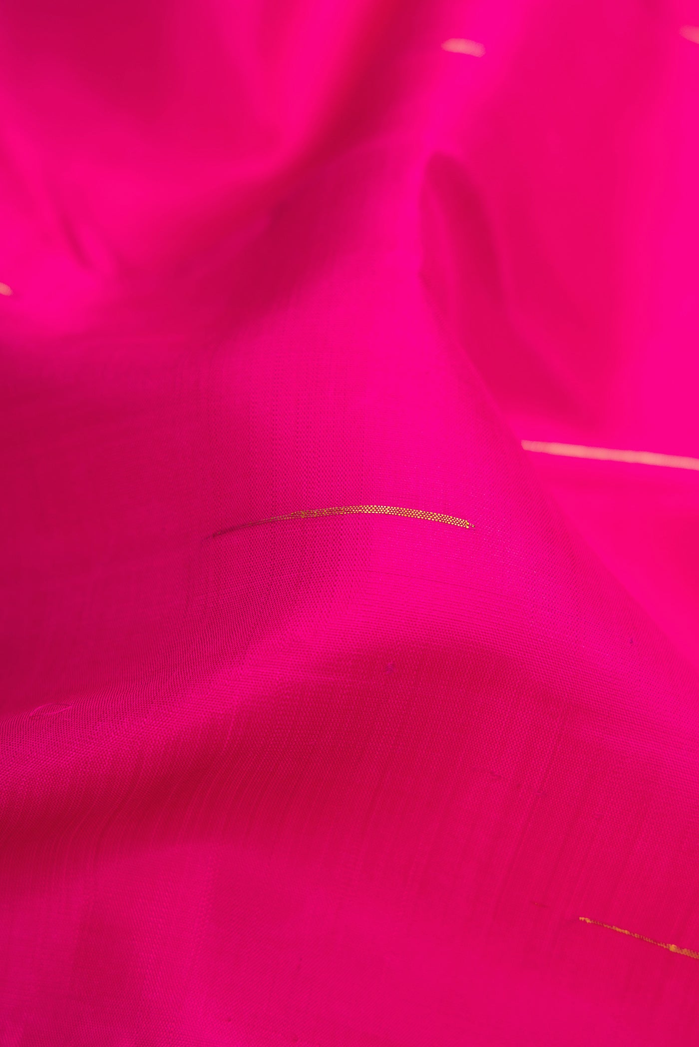 Close up of Pink Kanchipuram Silk Saree with Zari Butta on the body and Zari Border.  displaying folds