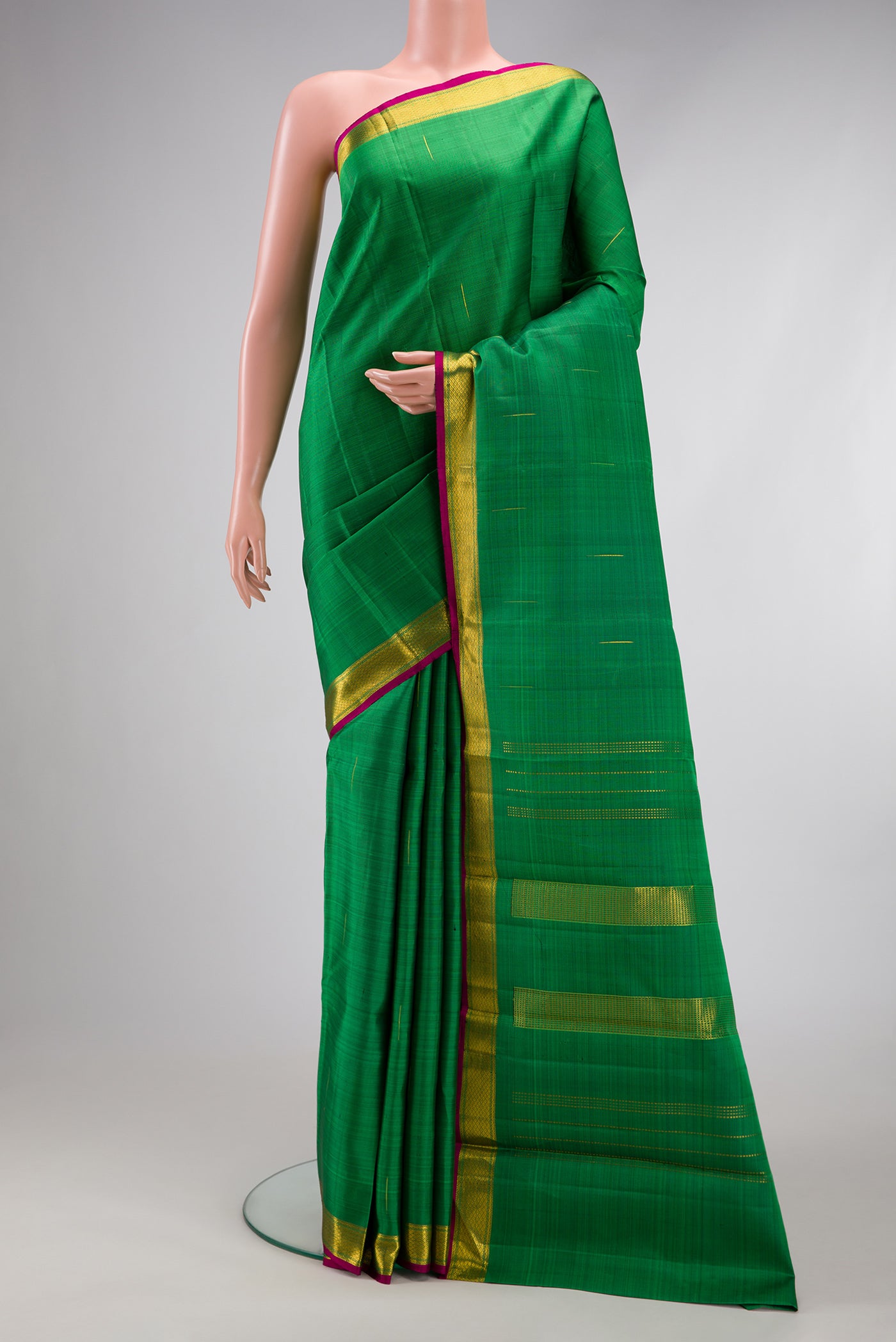 Green Kanchipuram Silk Saree with Zari Butta on the body and Zari Border.  displayed on a mannequin