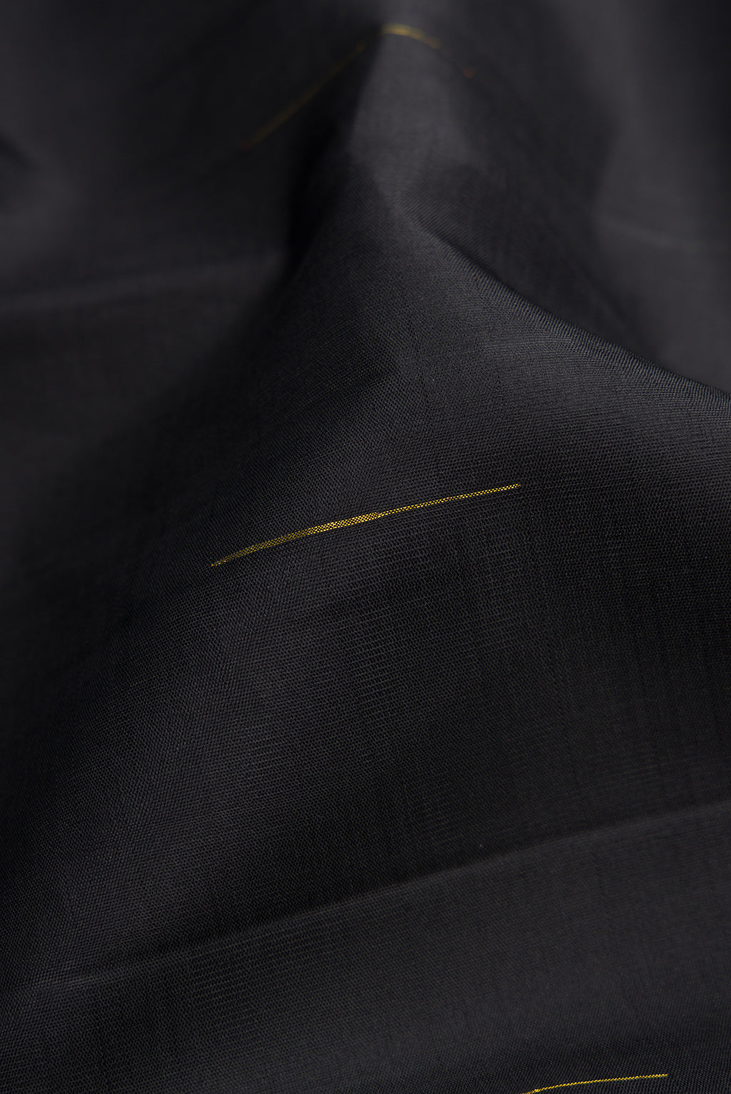 Close up of Black Kanchipuram Silk Saree with Zari Butta on the body and Zari Border.  displaying folds