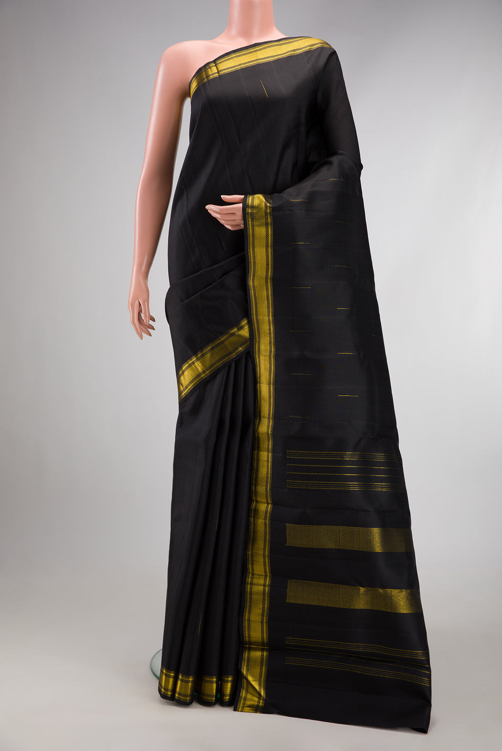 Black Kanchipuram Silk Saree with Zari Butta on the body and Zari Border.  displayed on a mannequin