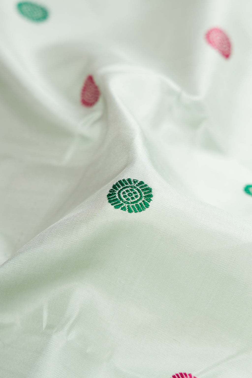 Close up of Pista Green Kanchipuram Silk Saree with Thread Butta on the body and Zari Border.  displaying folds