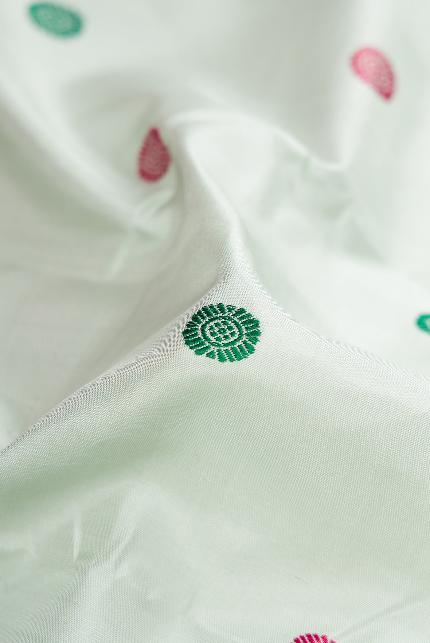 Close up of Pista Green Kanchipuram Silk Saree with Thread Butta on the body and Zari Border.  displaying folds
