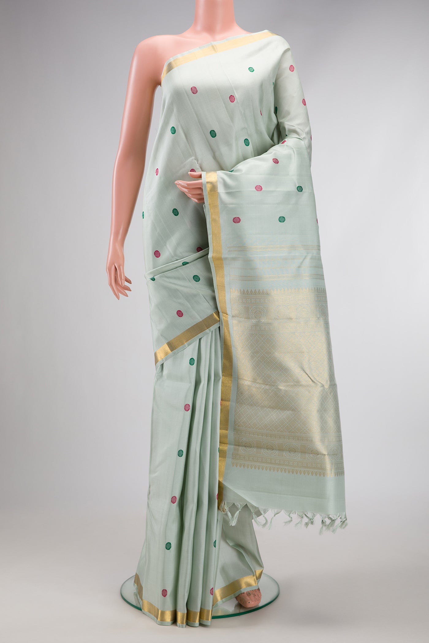 Pista Green Kanchipuram Silk Saree with Thread Butta on the body and Zari Border.  displayed on a mannequin