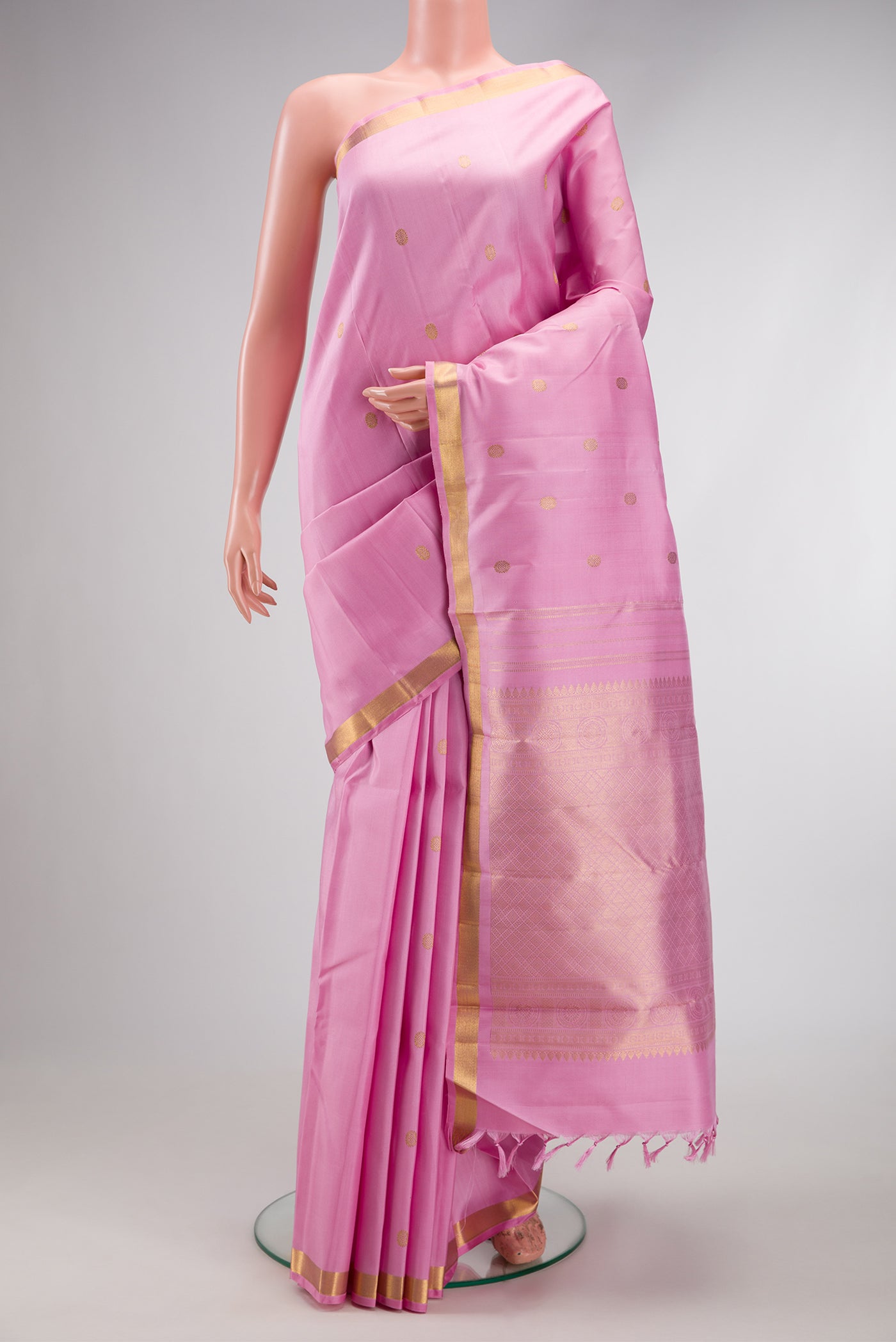 Pink Kanchipuram Silk Saree with Zari Butta on the body and Zari Border.  displayed on a mannequin