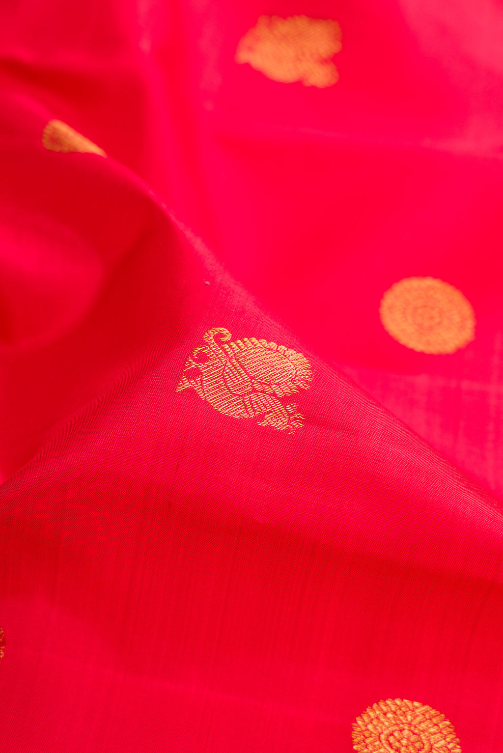 Close up of Red Kanchipuram Silk Saree with Zari Butta on the body and Zari Border.  displaying folds