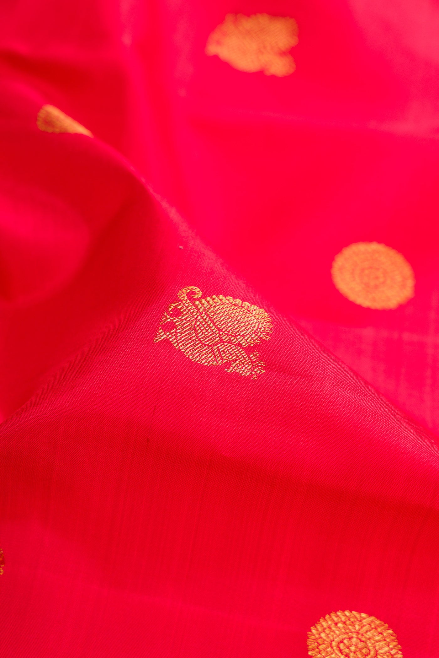 Close up of Red Kanchipuram Silk Saree with Zari Butta on the body and Zari Border.  displaying folds