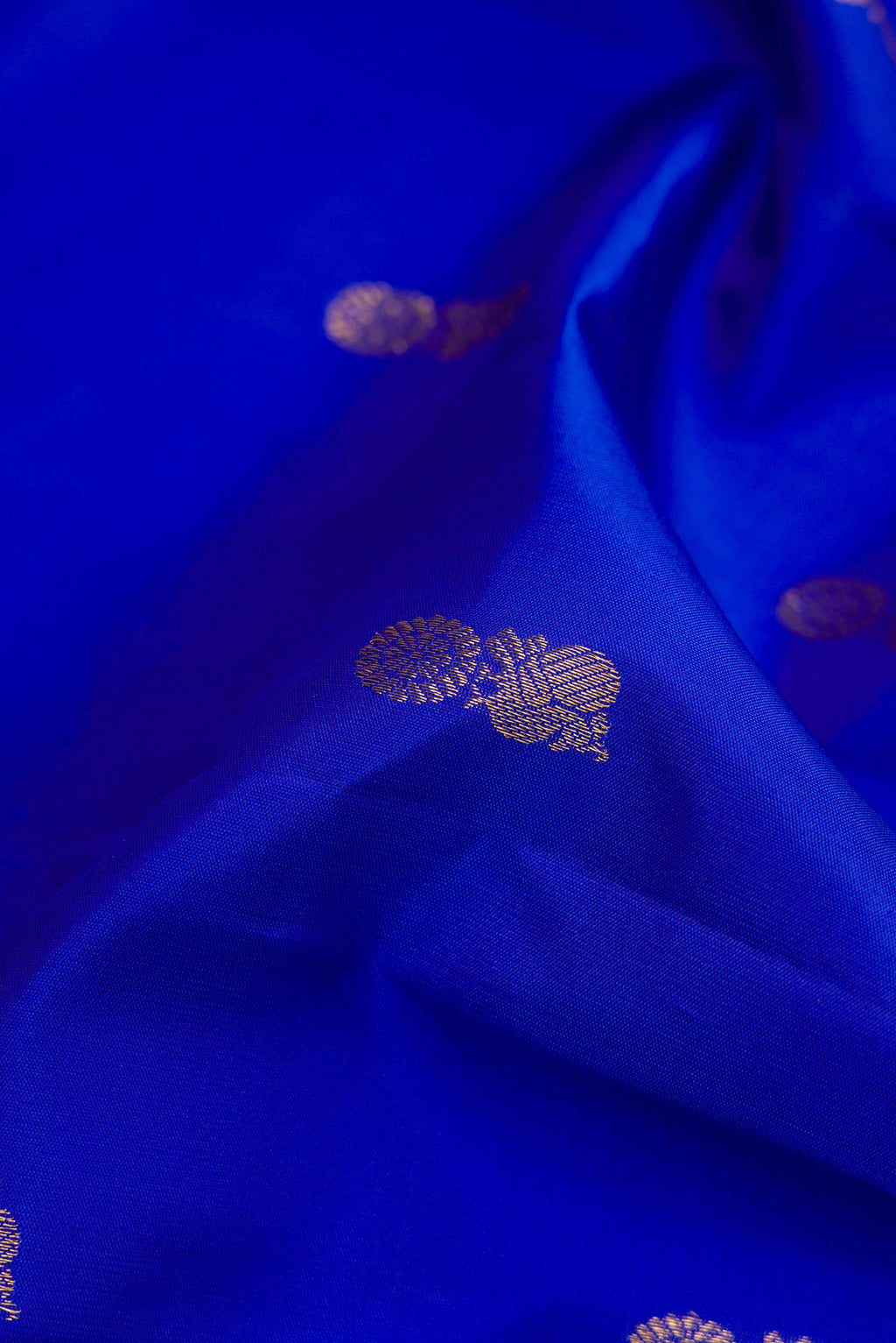 Close up of Royal Blue Dual Tone Kanchipuram Silk Saree with Zari Butta on the body and Zari Border.  displaying folds