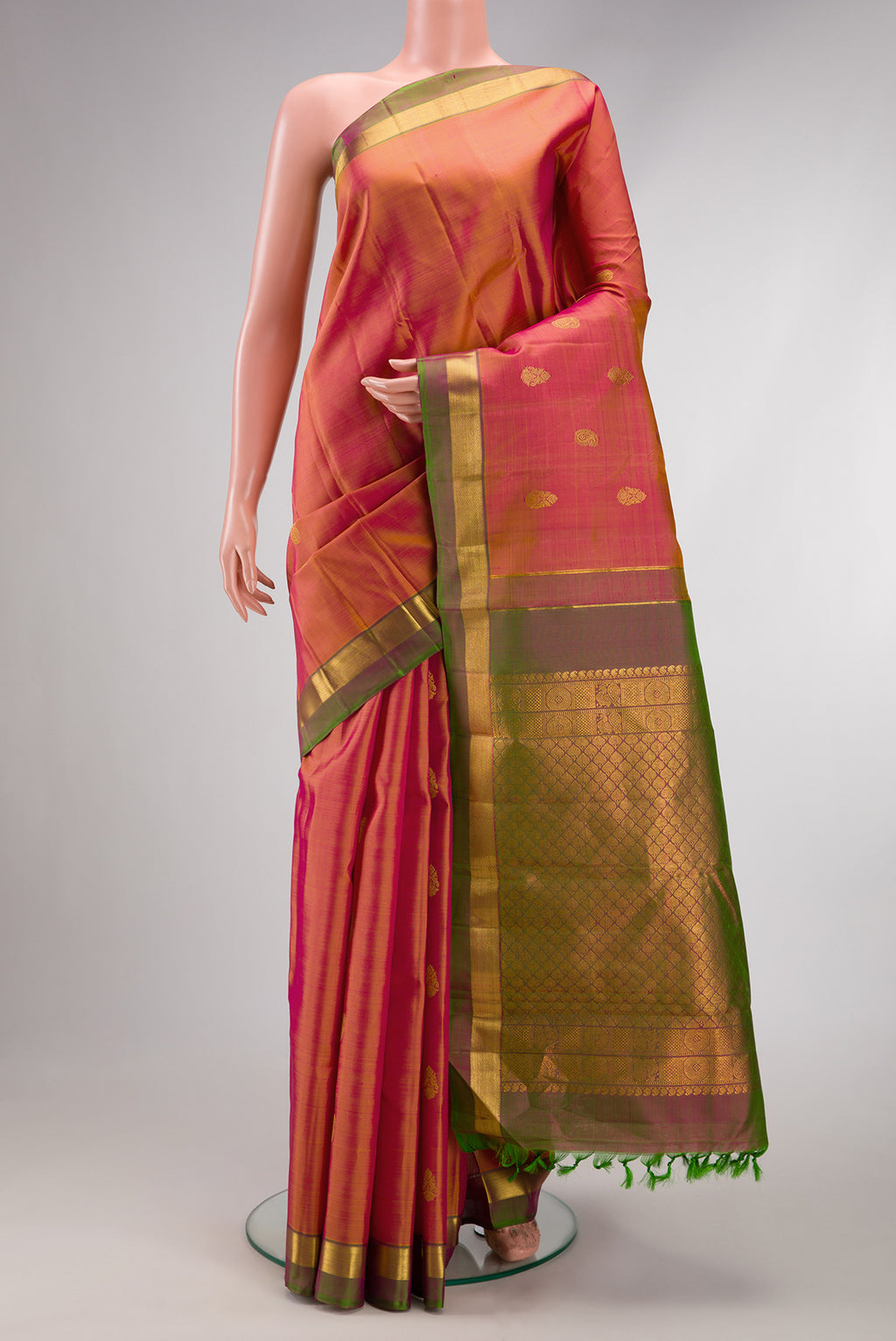 Orange Dual Tone Kanchipuram Silk Saree with Zari Butta on the body and Zari Border.  displayed on a mannequin