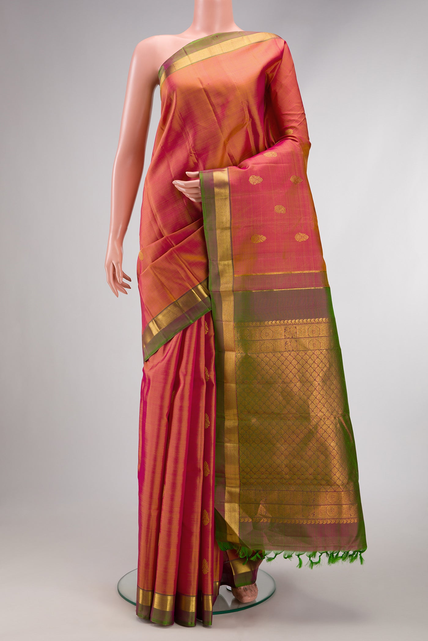 Orange Dual Tone Kanchipuram Silk Saree with Zari Butta on the body and Zari Border.  displayed on a mannequin