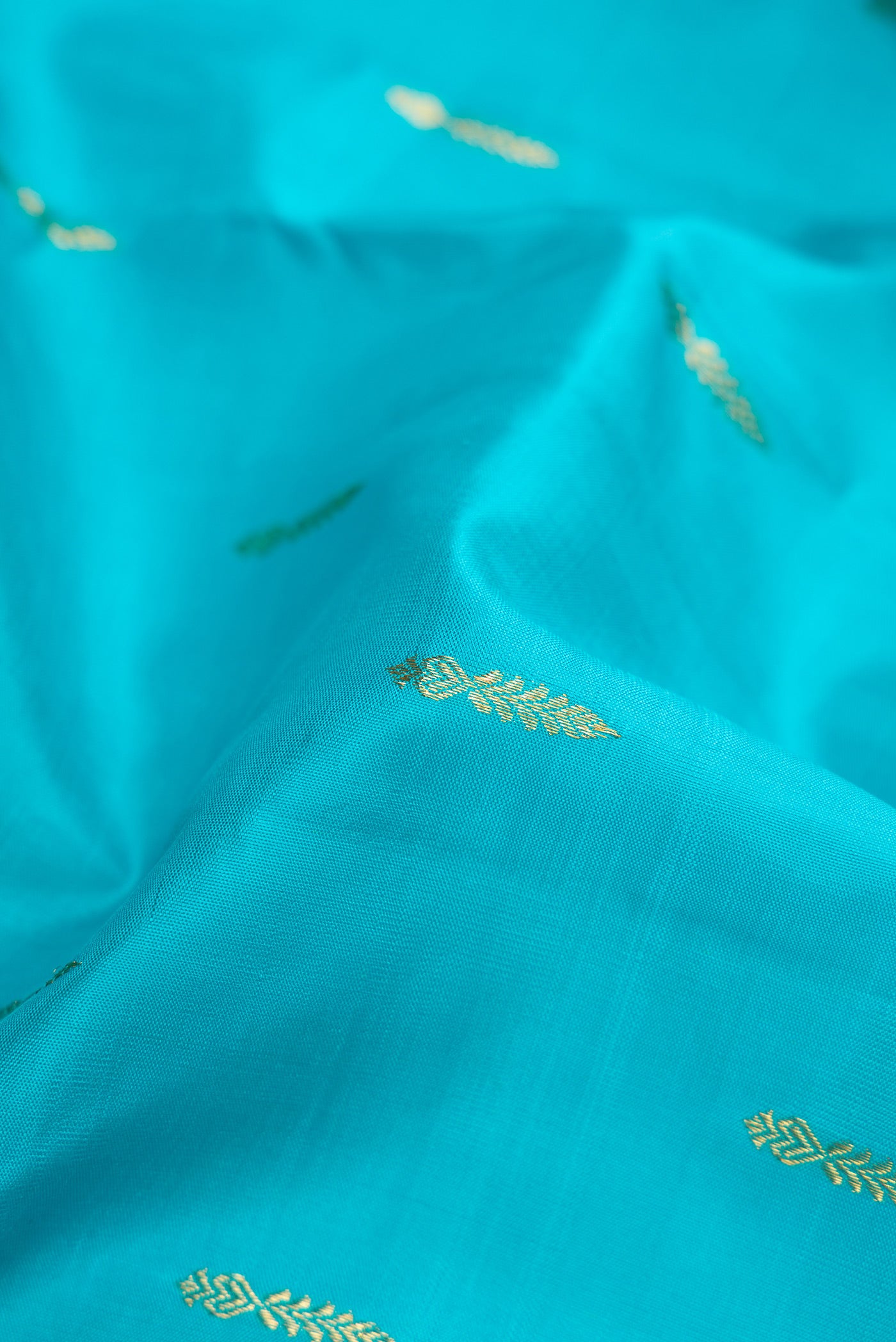 Close up of Sky Blue Dual Tone Kanchipuram Silk Saree with Zari Butta on the body and Zari Border.  displaying folds