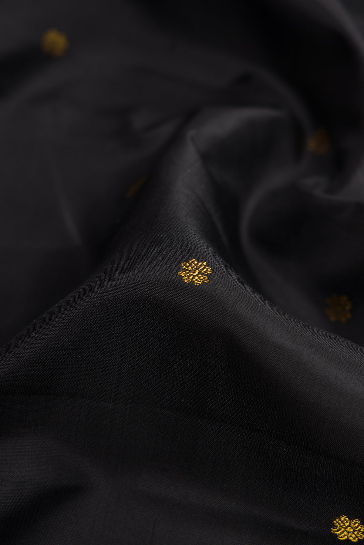 Close up of Black Dual Tone Soft Silk Saree with Zari Butta on the body and Fancy Border.  displaying folds