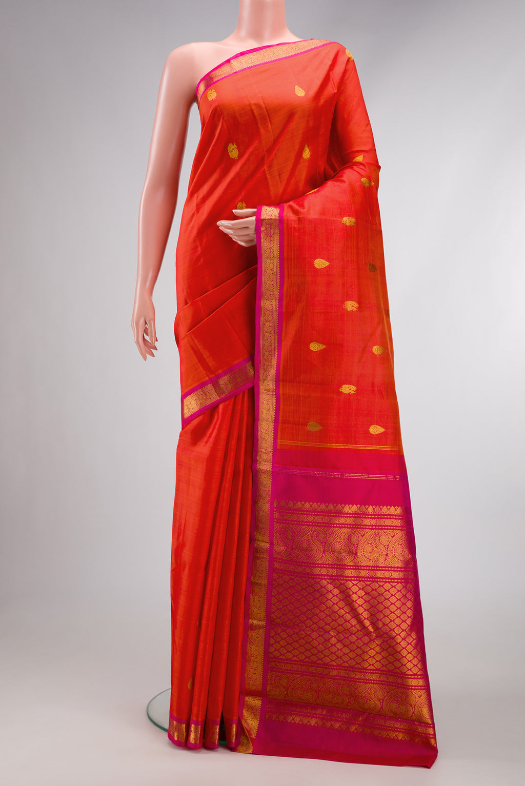 Coral Dual Tone Kanchipuram Silk Saree with Zari Butta on the body and Zari Border.  displayed on a mannequin