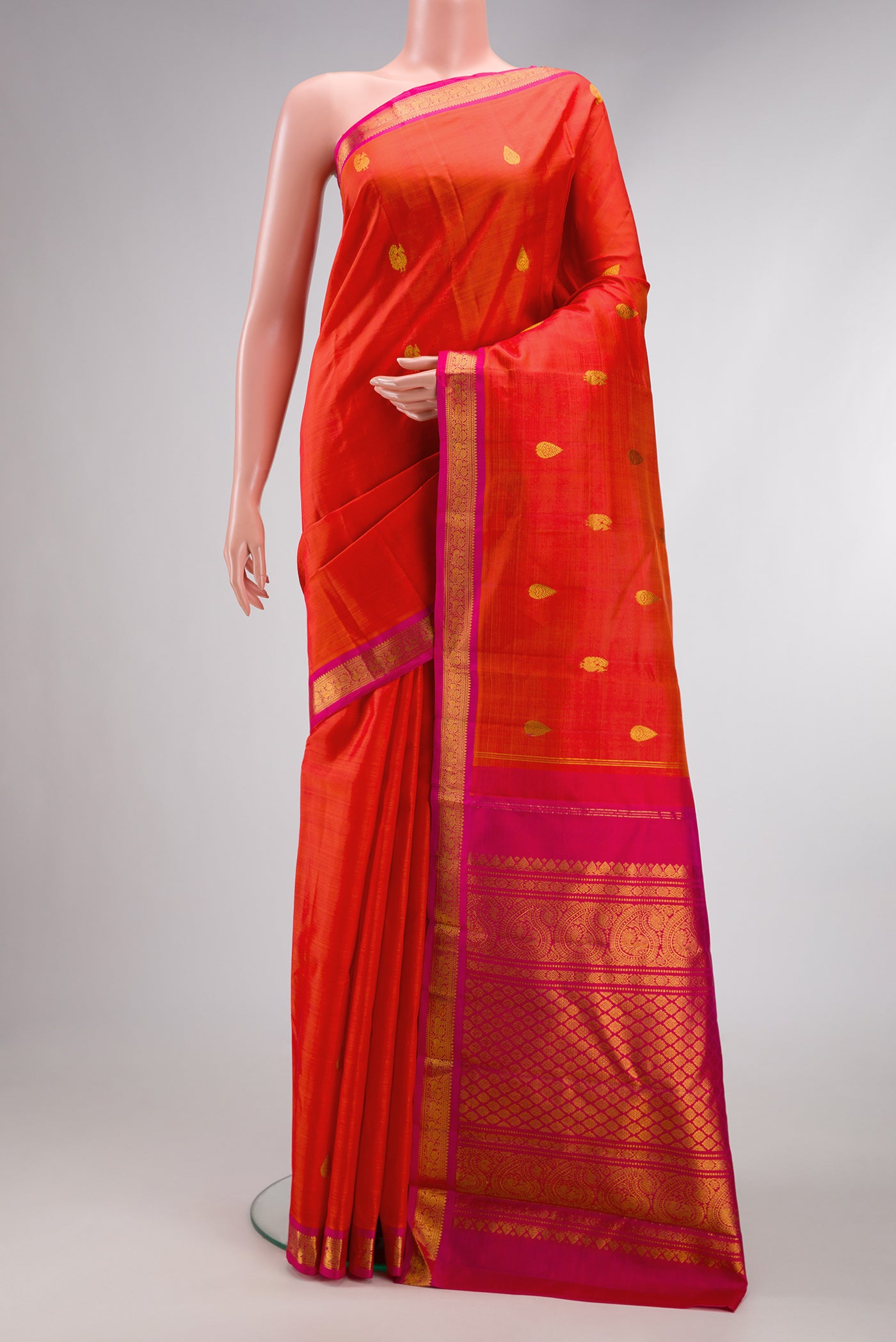 Coral Dual Tone Kanchipuram Silk Saree with Zari Butta on the body and Zari Border.  displayed on a mannequin