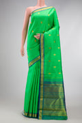 Parrot Green Kanchipuram Silk Saree with Zari Butta on the body and Zari Border.  displayed on a mannequin