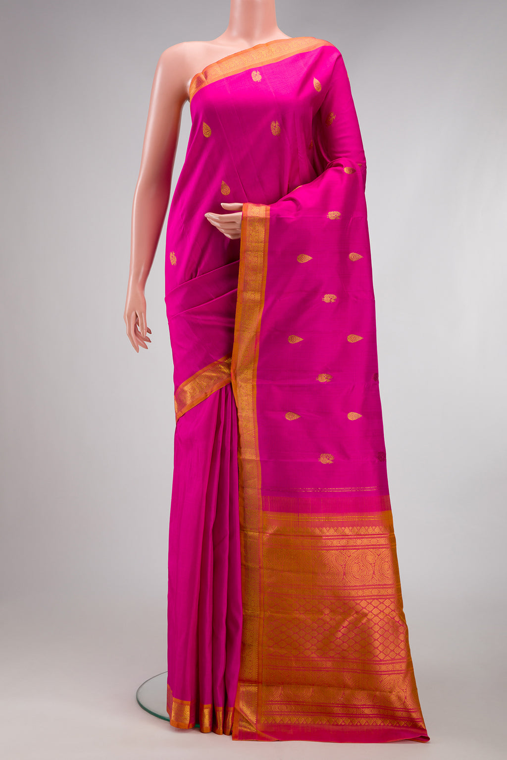 Pink Kanchipuram Silk Saree with Zari Butta on the body and Zari Border.  displayed on a mannequin