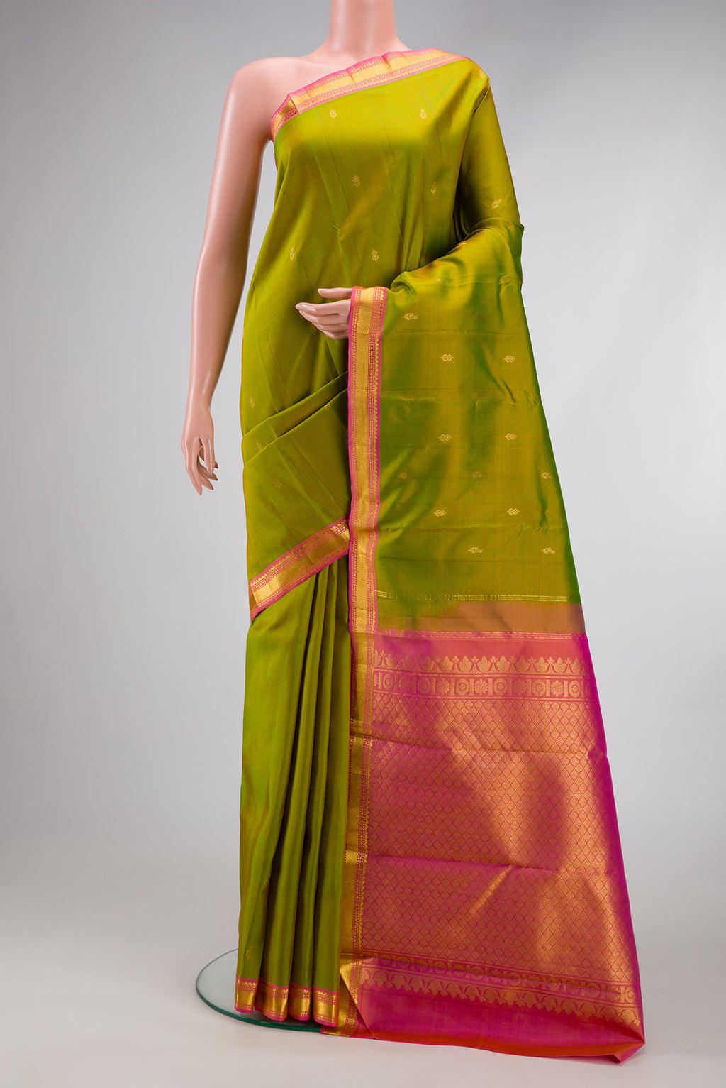 Mehandi Green Kanchipuram Silk Saree with Zari Butta on the body and Zari Border.  displayed on a mannequin