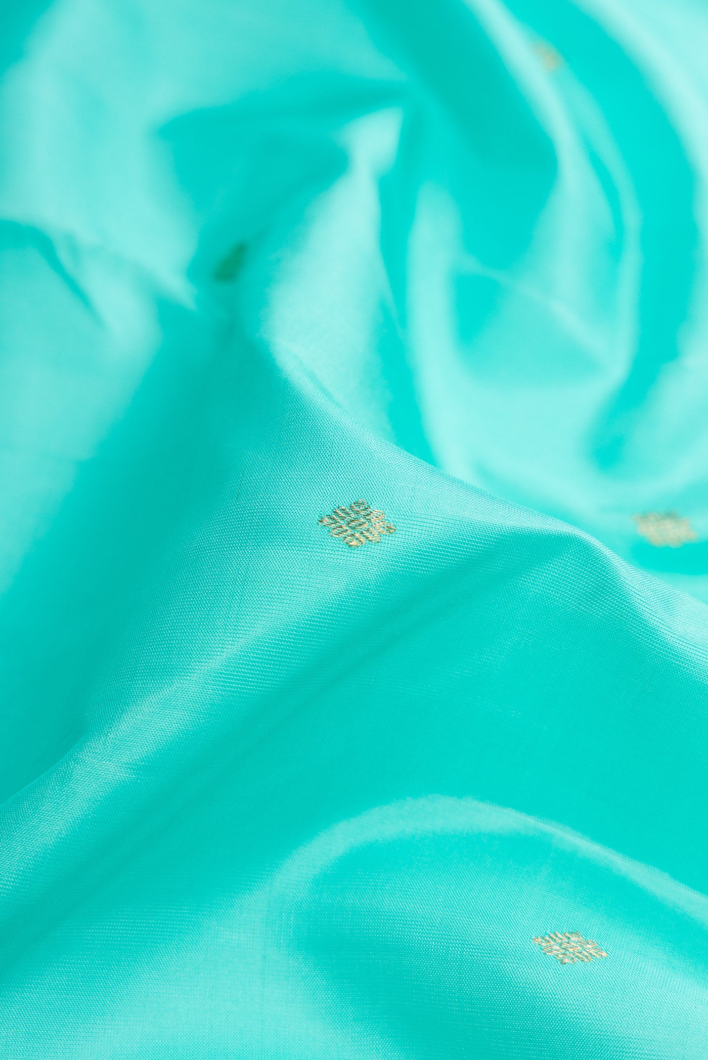Close up of Sky Blue Dual Tone Kanchipuram Silk Saree with Zari Butta on the body and Zari Border.  displaying folds