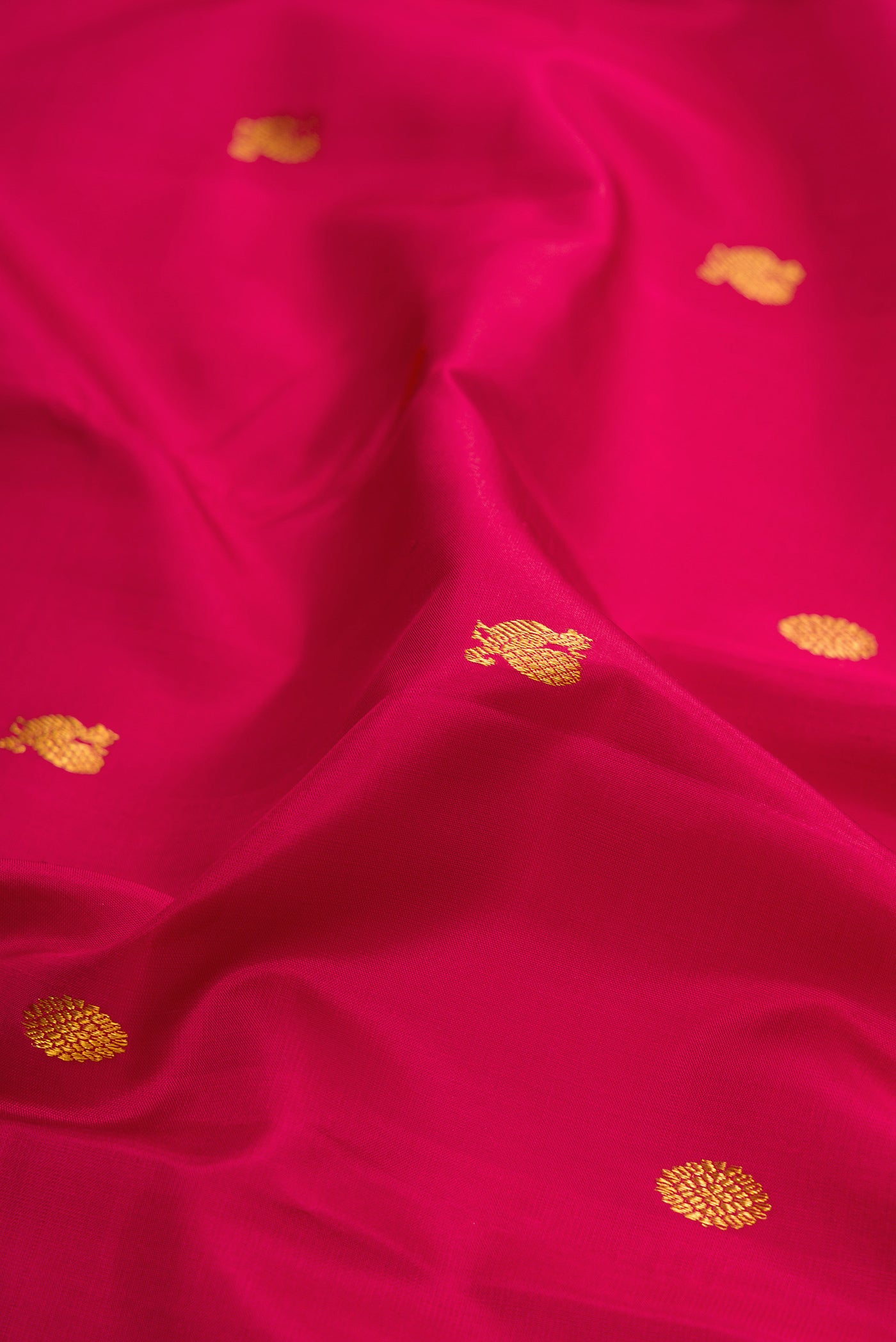 Close up of Maroon Kanchipuram Silk Saree with Zari Butta on the body and Zari Border.  displaying folds