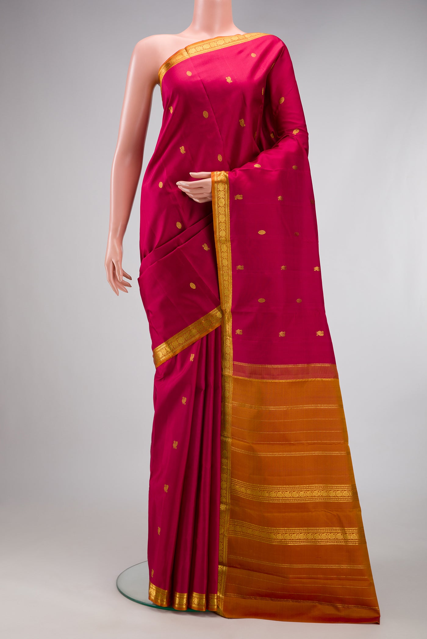 Maroon Kanchipuram Silk Saree with Zari Butta on the body and Zari Border.  displayed on a mannequin