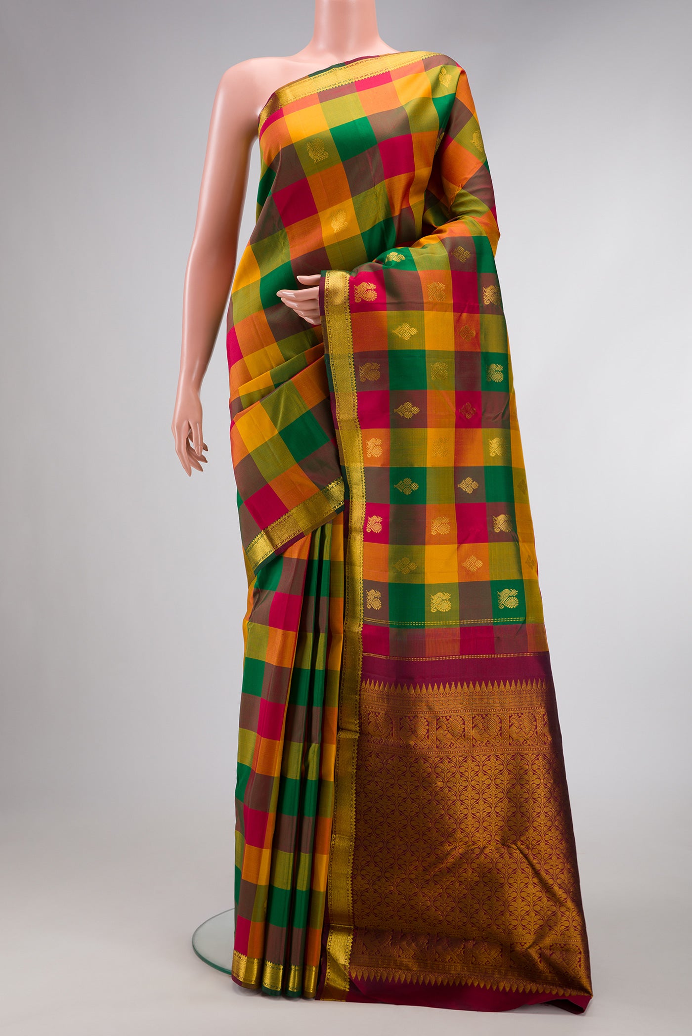 Multi Color Kanchipuram Silk Saree with Checked design on the body and Zari Border.  displayed on a mannequin