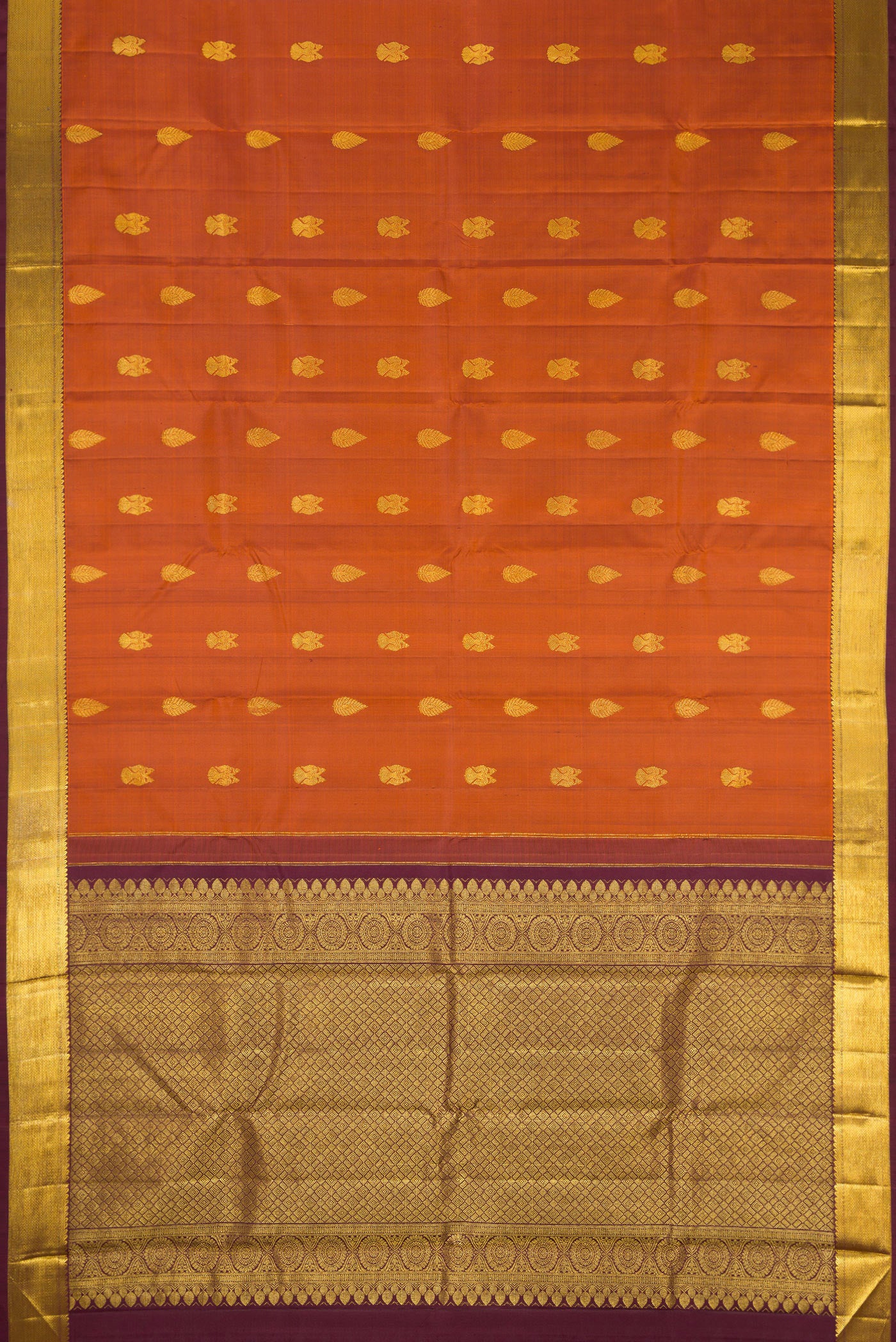 Flat view of Brick Orange Dual Tone Kanjivaram Silk Saree with Zari Butta on the body and Zari Border. 