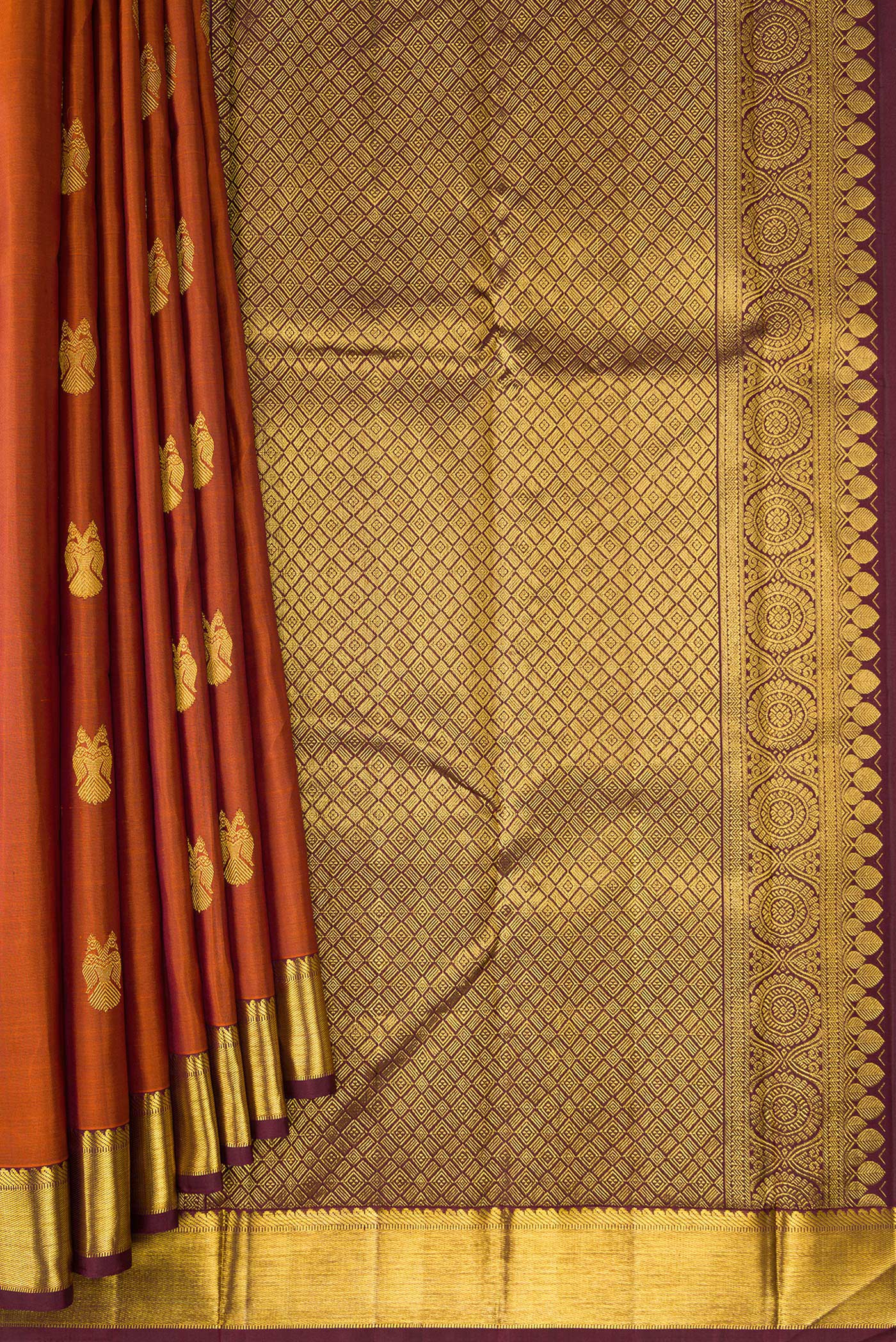 Pleats and pallu of Brick Orange Dual Tone Kanjivaram Silk Saree with Zari Butta on the body and Zari Border. 
