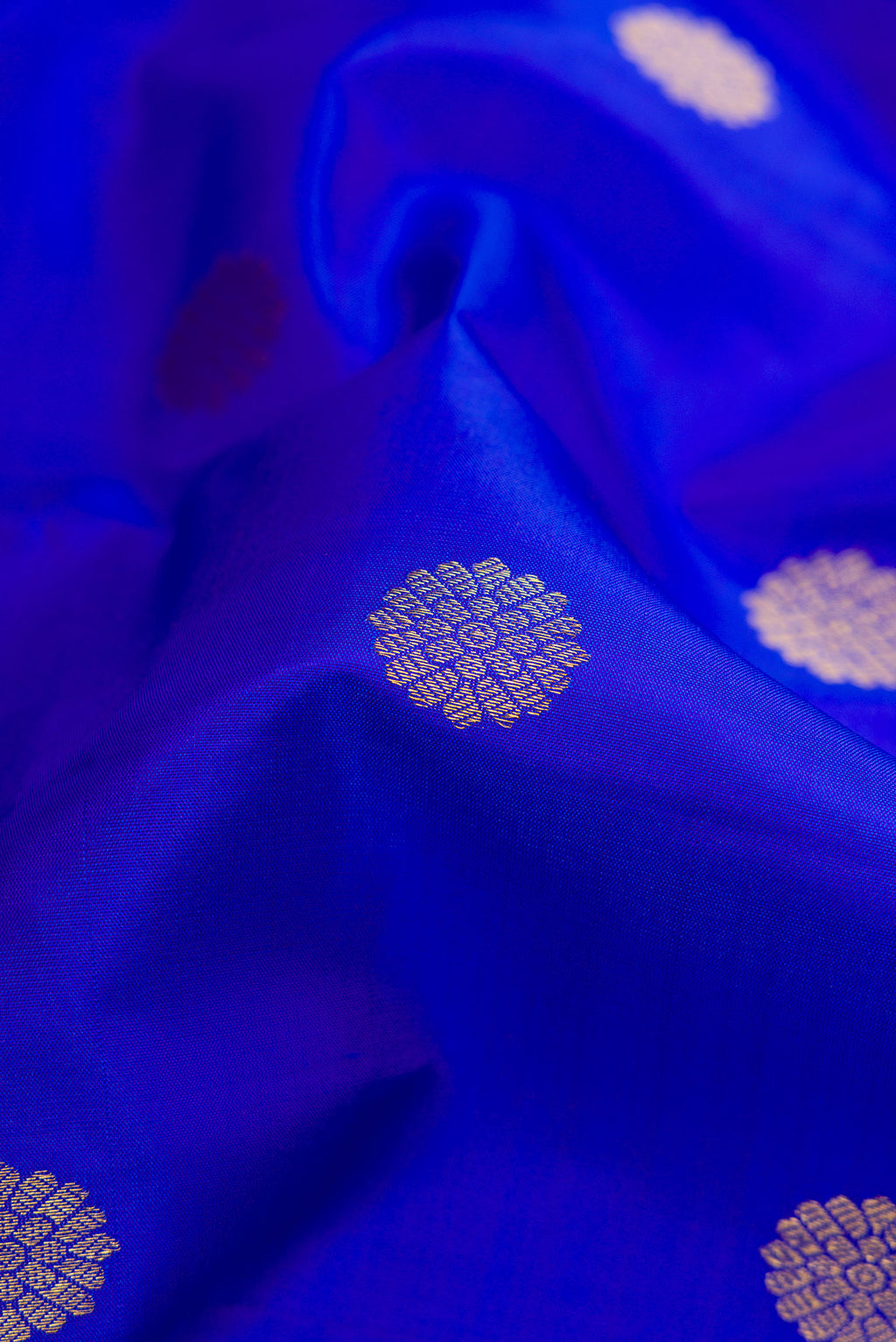 Close up of Royal Blue Dual Tone Kanjivaram Silk Saree with Zari Butta on the body and Zari Border.  displaying folds