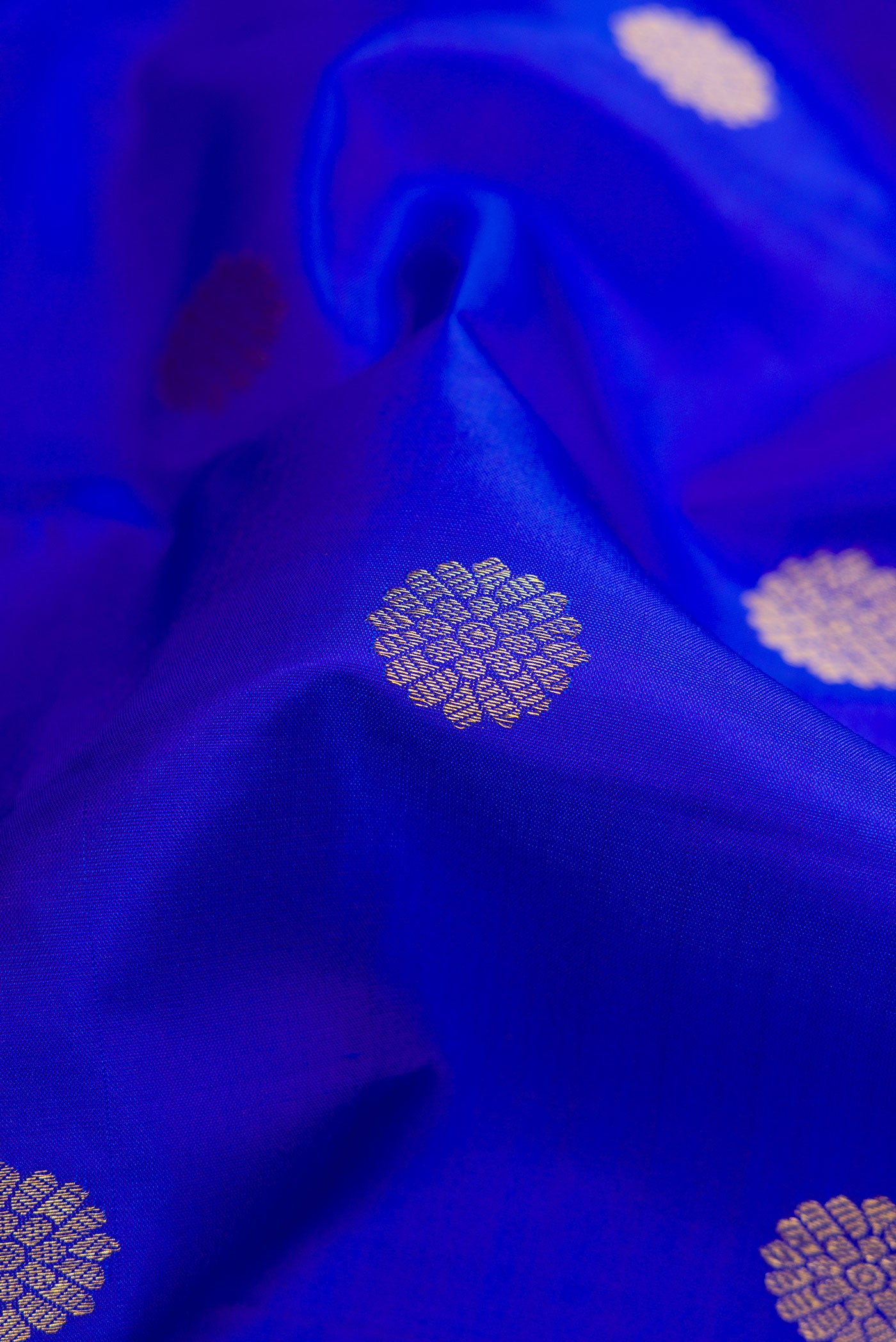 Close up of Royal Blue Dual Tone Kanjivaram Silk Saree with Zari Butta on the body and Zari Border.  displaying folds