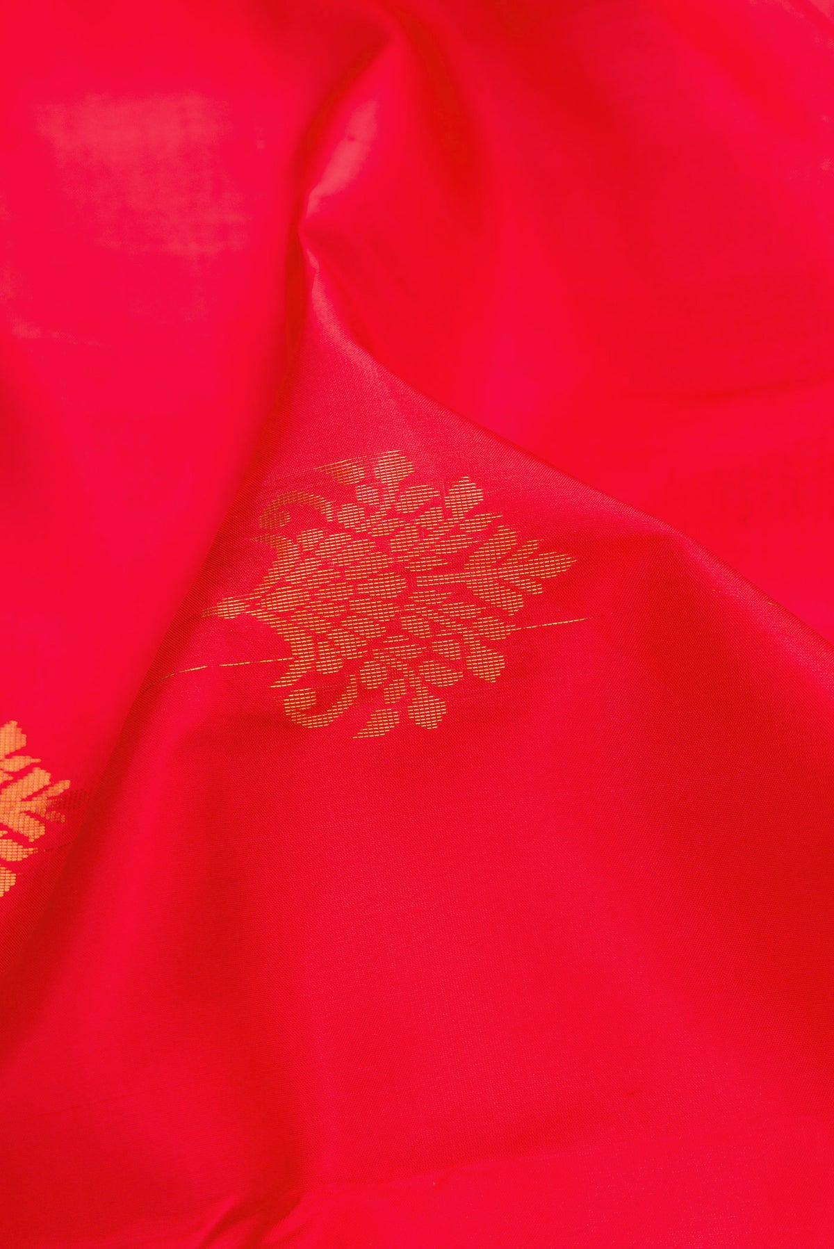Close up of Red Soft Silk Saree with Zari Butta on the body and Fancy Border.  displaying folds