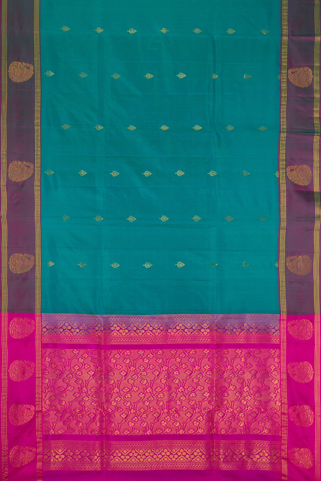 Flat view of Teal Soft Silk Saree with Zari Butta on the body and Fancy Border. 