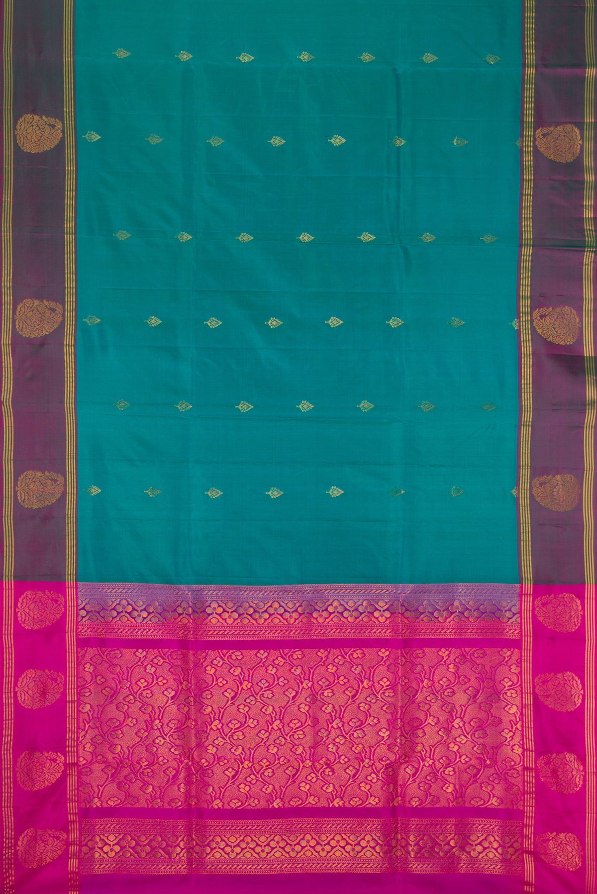 Teal Soft Silk Saree with Zari Butta on the body and Fancy Border.  displayed on a mannequin