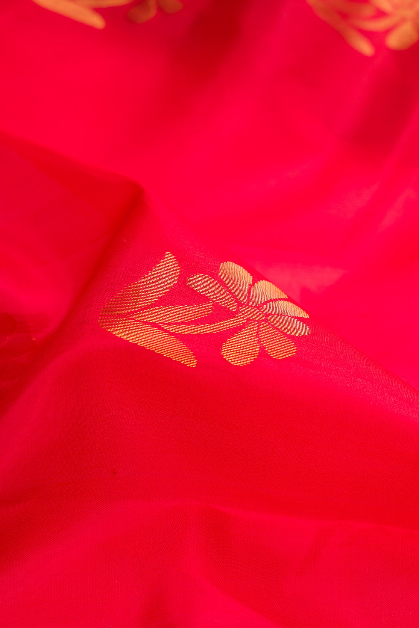 Close up of Red Soft Silk Saree with Zari Butta on the body and Fancy Border.  displaying folds