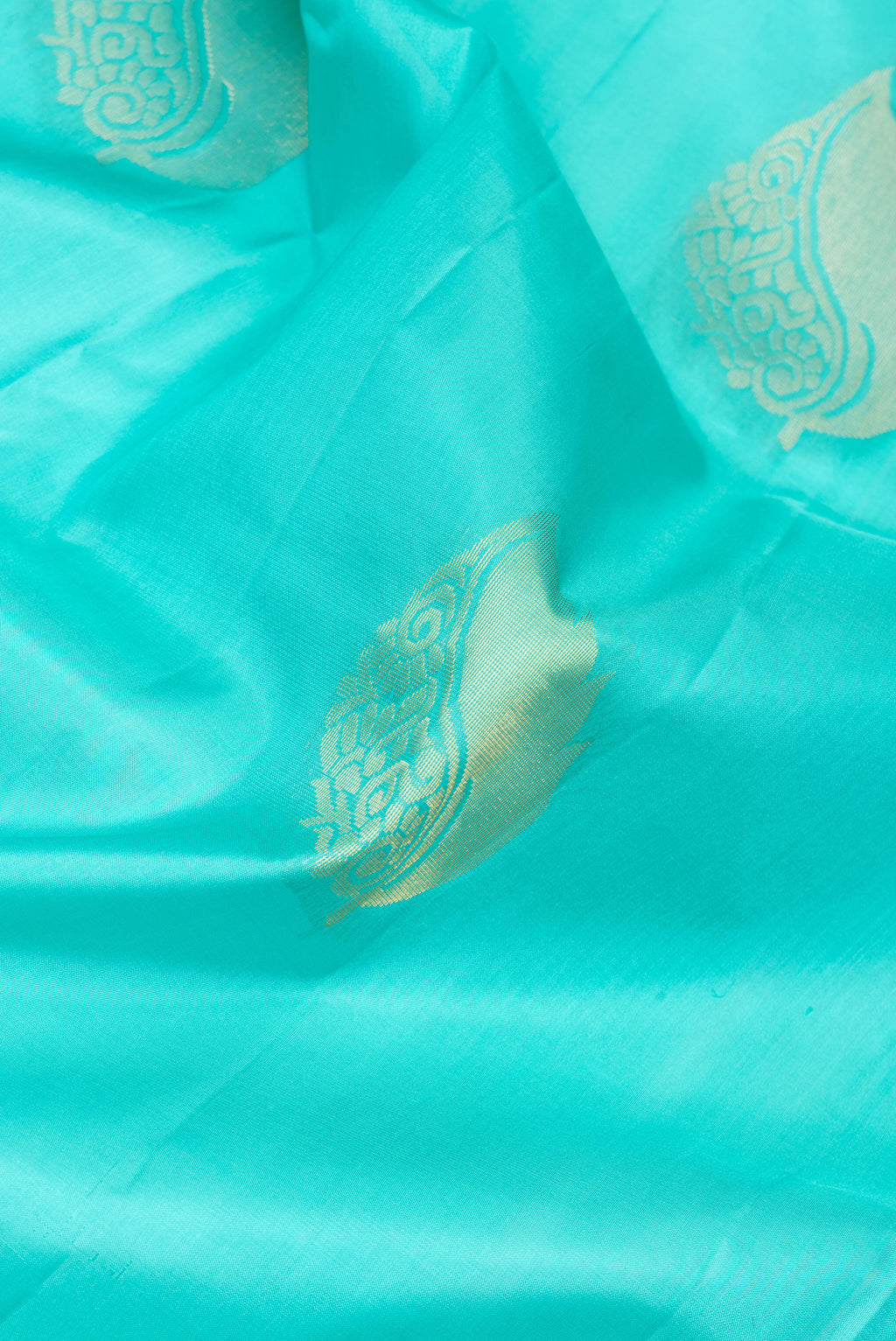 Close up of Sky Blue Soft Silk Saree with Zari Butta on the body and Fancy Border.  displaying folds