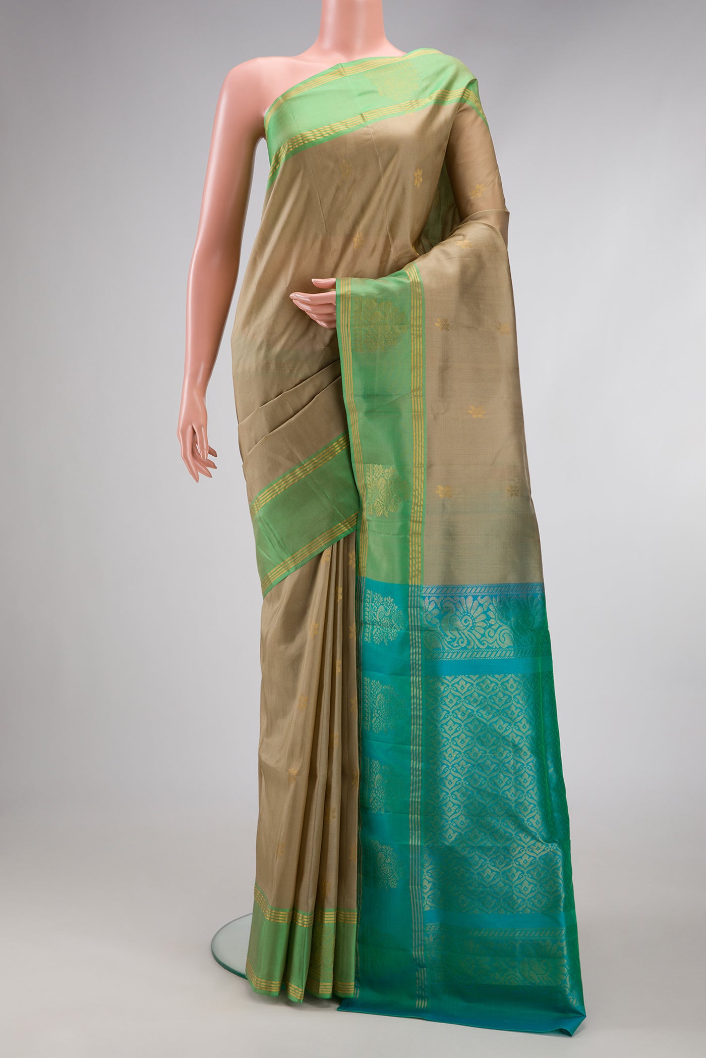 Beige Soft Silk Saree with Zari Butta on the body and Fancy Border.  displayed on a mannequin