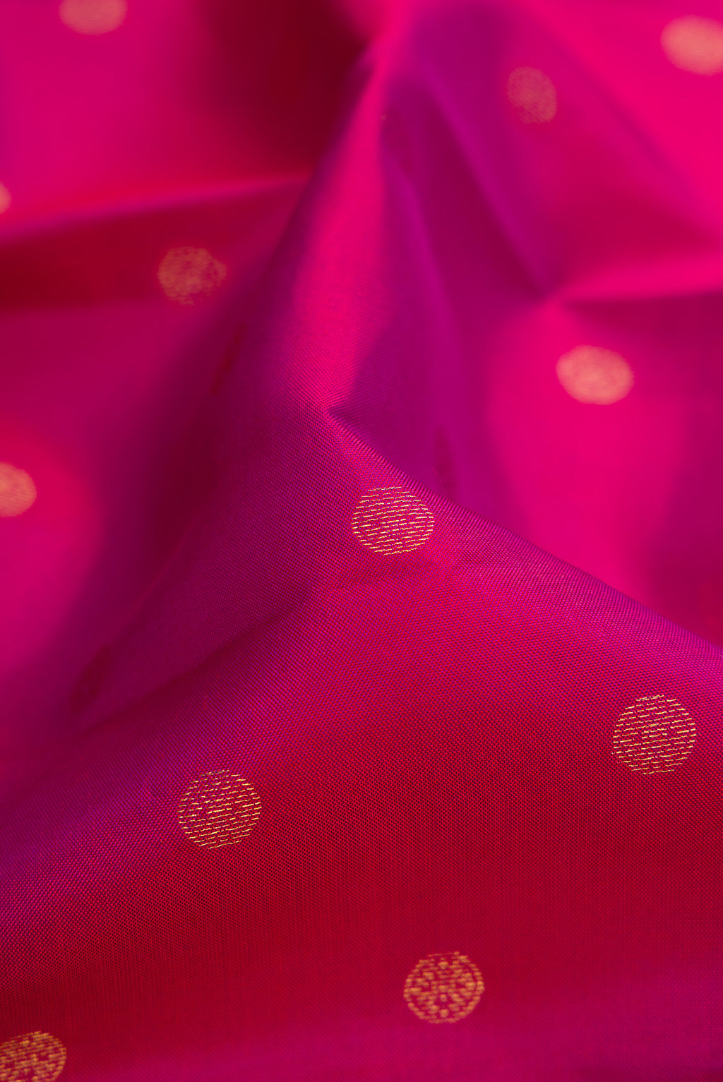 Close up of Magenta Kanchipuram Silk Saree with Zari Butta on the body and Temple Border.  displaying folds