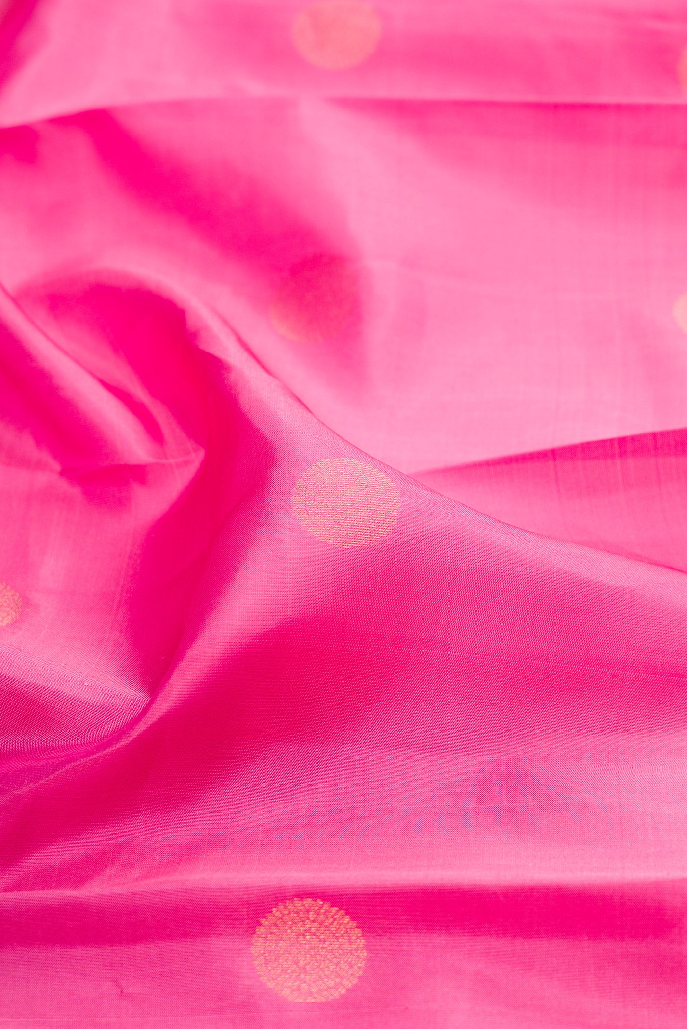 Close up of Rose Gold Kanchipuram Silk Saree with Zari Butta on the body and Zari Border.  displaying folds