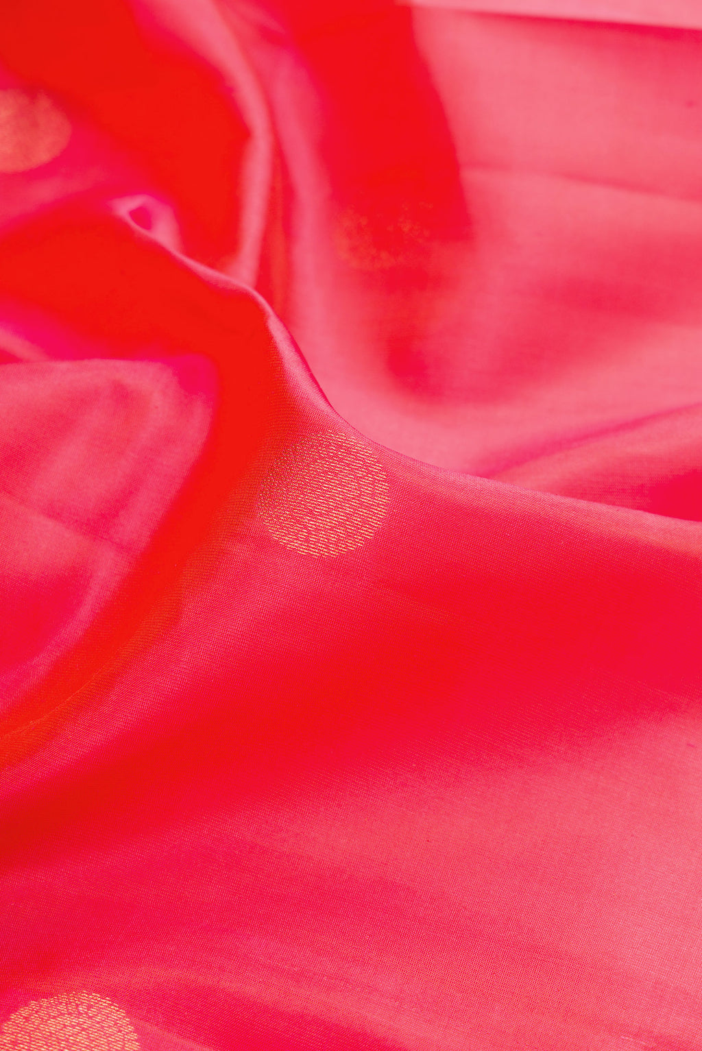 Close up of Coral Dual Tone Kanchipuram Silk Saree with Zari Butta on the body and Zari Border.  displaying folds