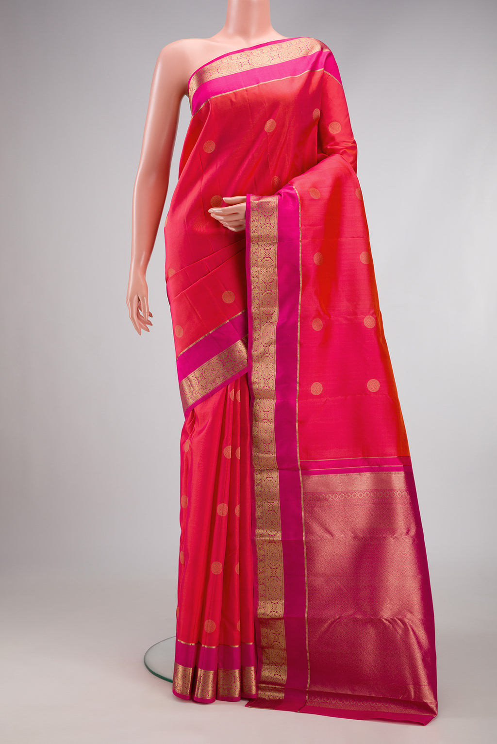 Coral Dual Tone Kanchipuram Silk Saree with Zari Butta on the body and Zari Border.  displayed on a mannequin