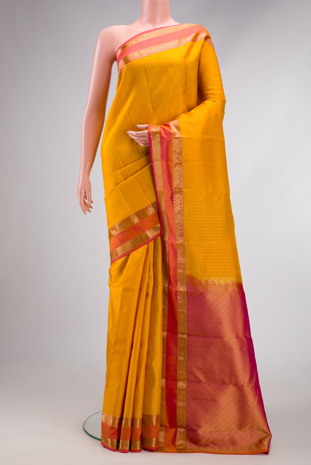 Yellow Dual Tone Kanchipuram Silk Saree with Zari Butta on the body and Zari Border.  displayed on a mannequin