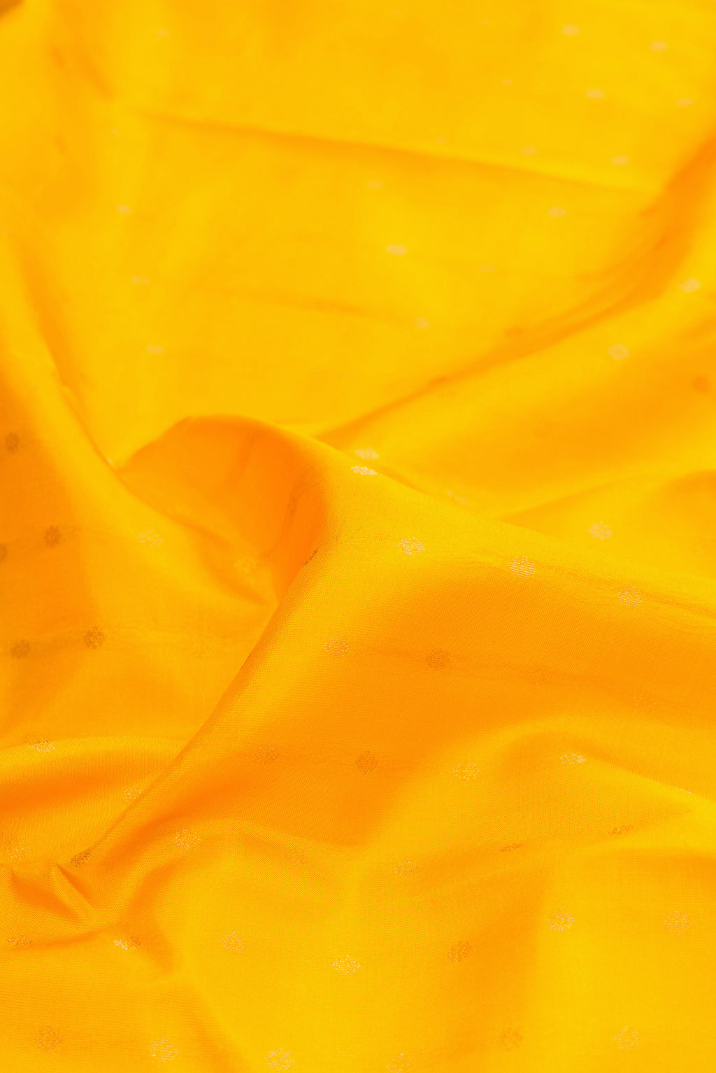 Close up of Yellow Kanchipuram Silk Saree with Zari Butta on the body and Zari Border.  displaying folds