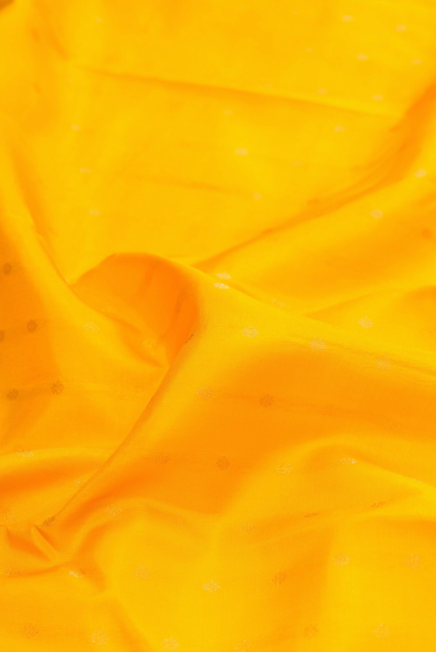 Close up of Yellow Kanchipuram Silk Saree with Zari Butta on the body and Zari Border.  displaying folds