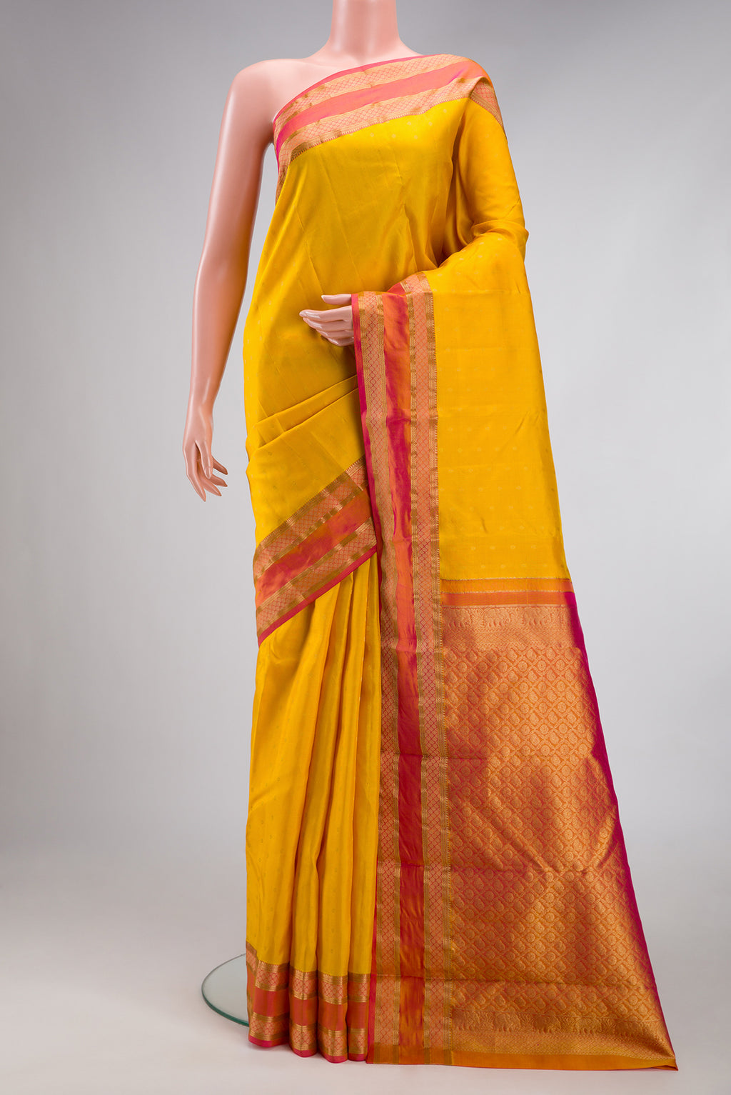 Yellow Kanchipuram Silk Saree with Zari Butta on the body and Zari Border.  displayed on a mannequin