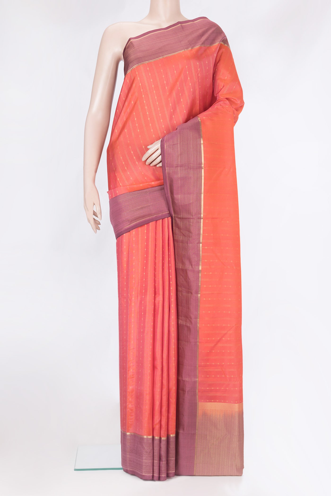Brick Orange Dual Tone Kanchipuram Silk Saree with Zari Butta on the body and Zari Border.  displayed on a mannequin