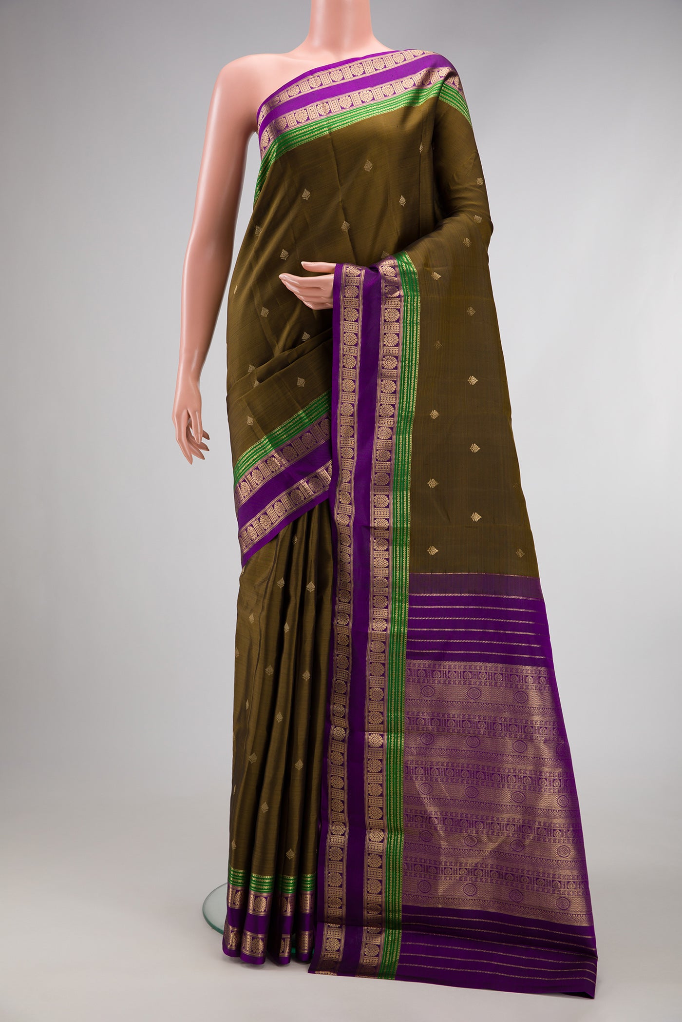 Mehandi Green Kanchipuram Silk Saree with Zari Butta on the body and Zari Border.  displayed on a mannequin
