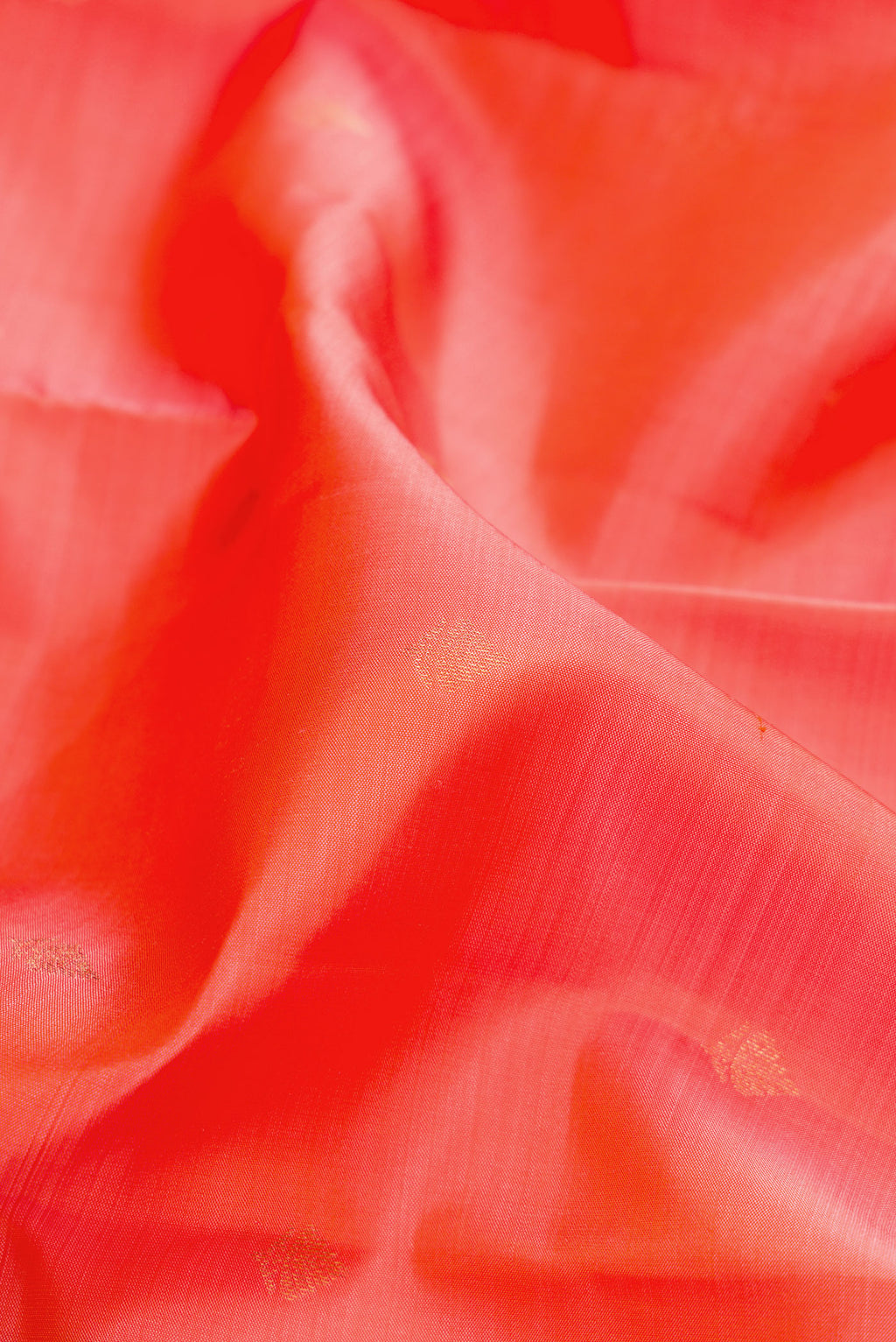 Close up of Orange Dual Tone Kanchipuram Silk Saree with Zari Butta on the body and Zari Border.  displaying folds