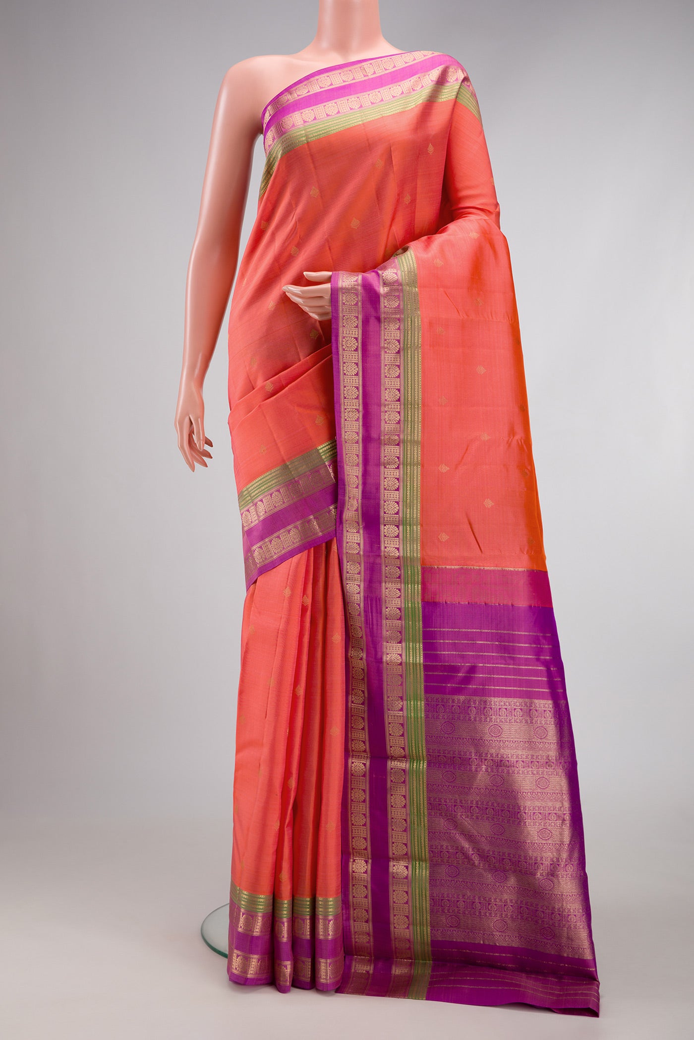 Orange Dual Tone Kanchipuram Silk Saree with Zari Butta on the body and Zari Border.  displayed on a mannequin